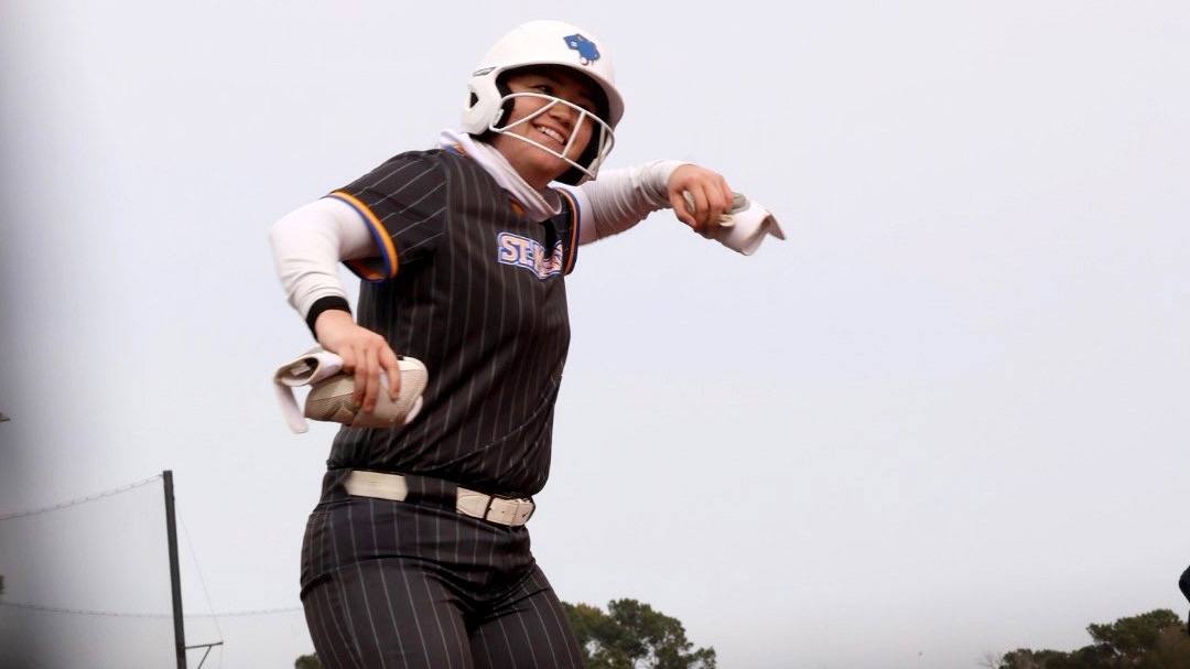 Miah Corona celebrates on third base after hitting a triple.