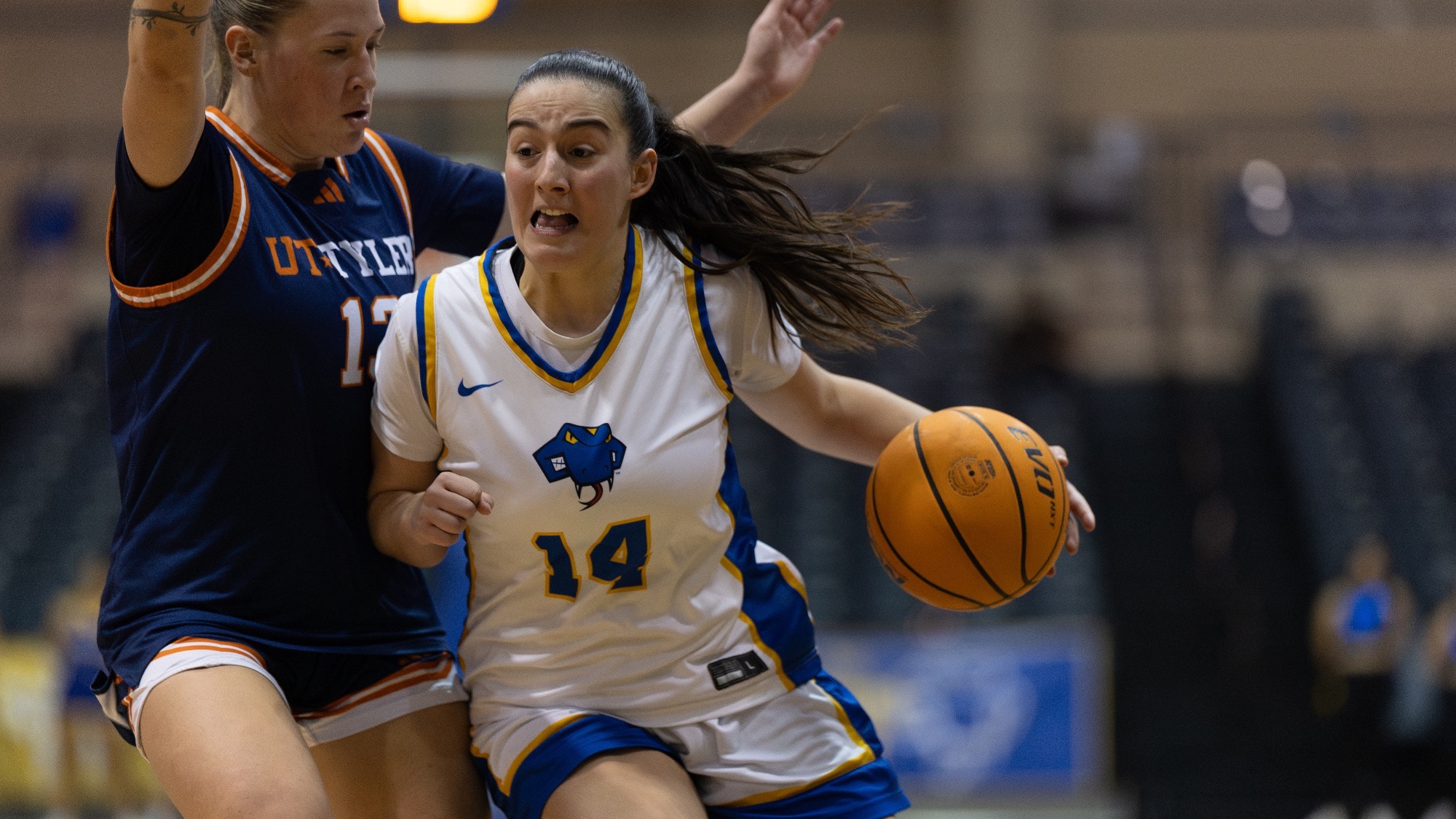 Aina Maynou drives the lane with the ball in her left hand and a defender on her right hip.