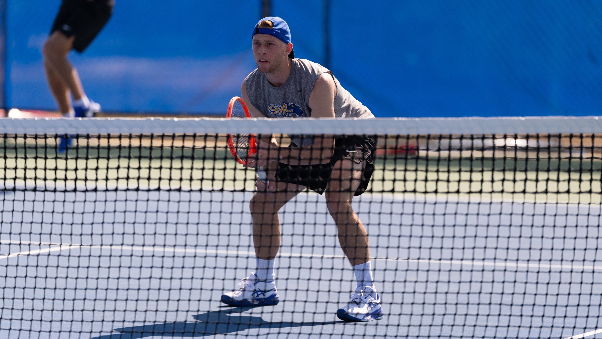 Florian Smalto squats at the net waiting for his doubles partner to serve.