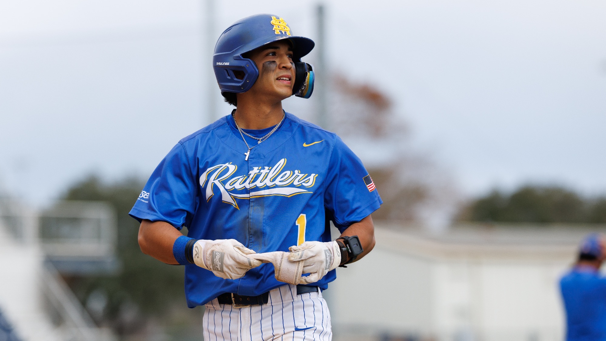 Jacob King looks off to the side as he begins taking off his batting glove.
