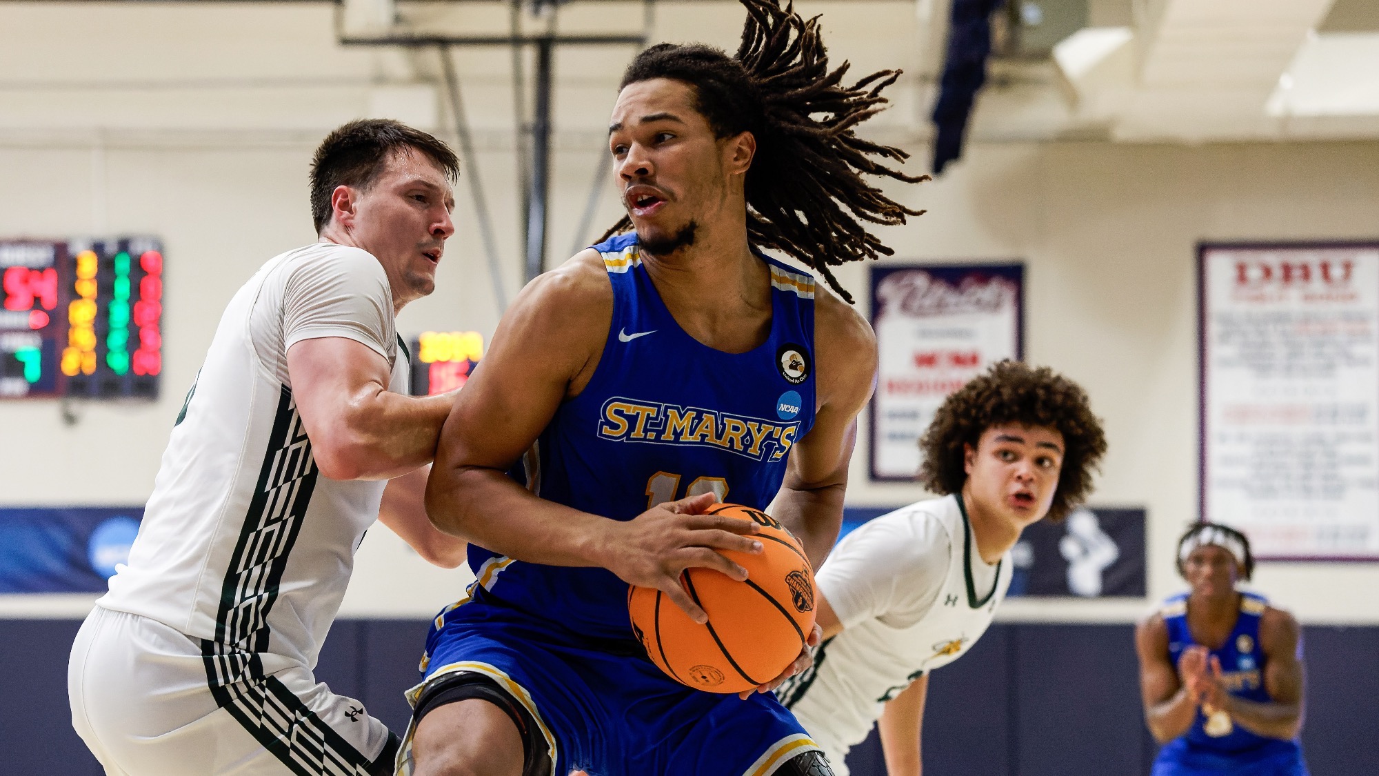 Justin Britt drives toward the basket with a defender in front of him and another closing from behind.