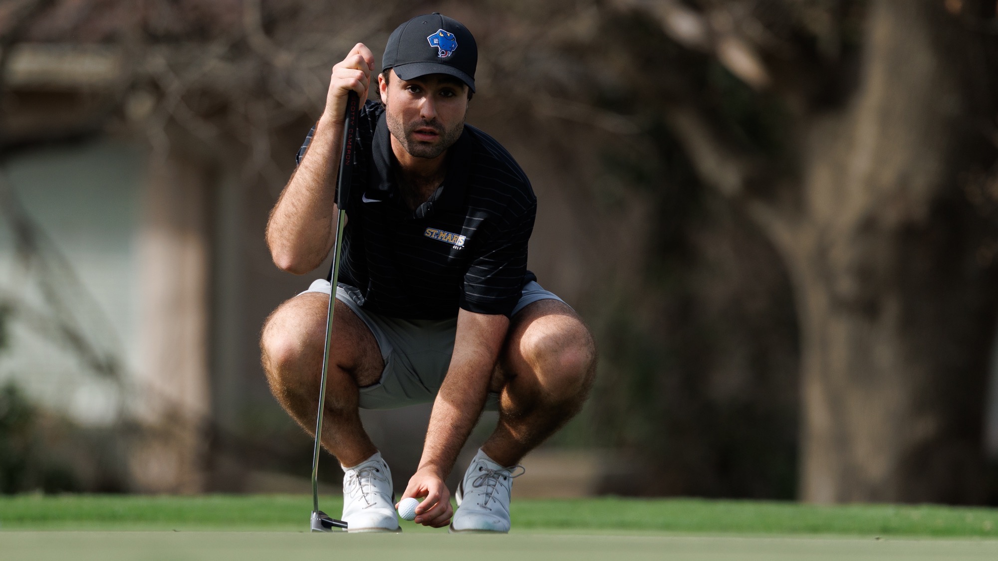 Guillaume Paquette squats down to place his ball and line up a putt at the Rattler Invitational.