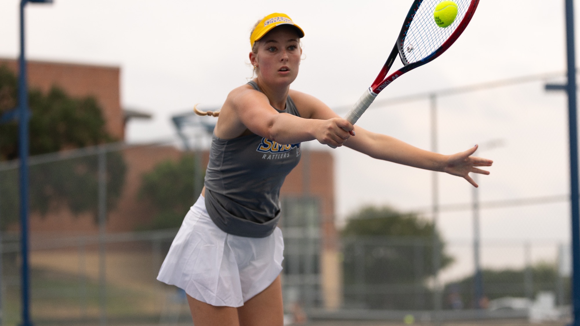 Isabella Olsson connects with a ball on a one-handed backhand.