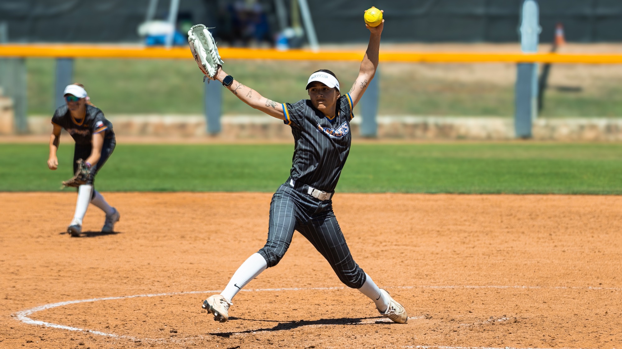 Emery Aguilar strides toward home plate in the top of her windmill motion.