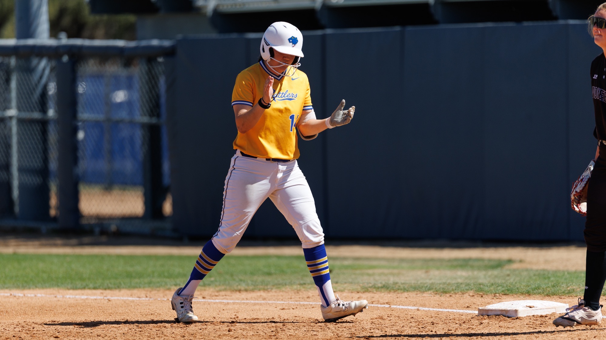 Miah Corona claps her hands after reaching first base on a hit.