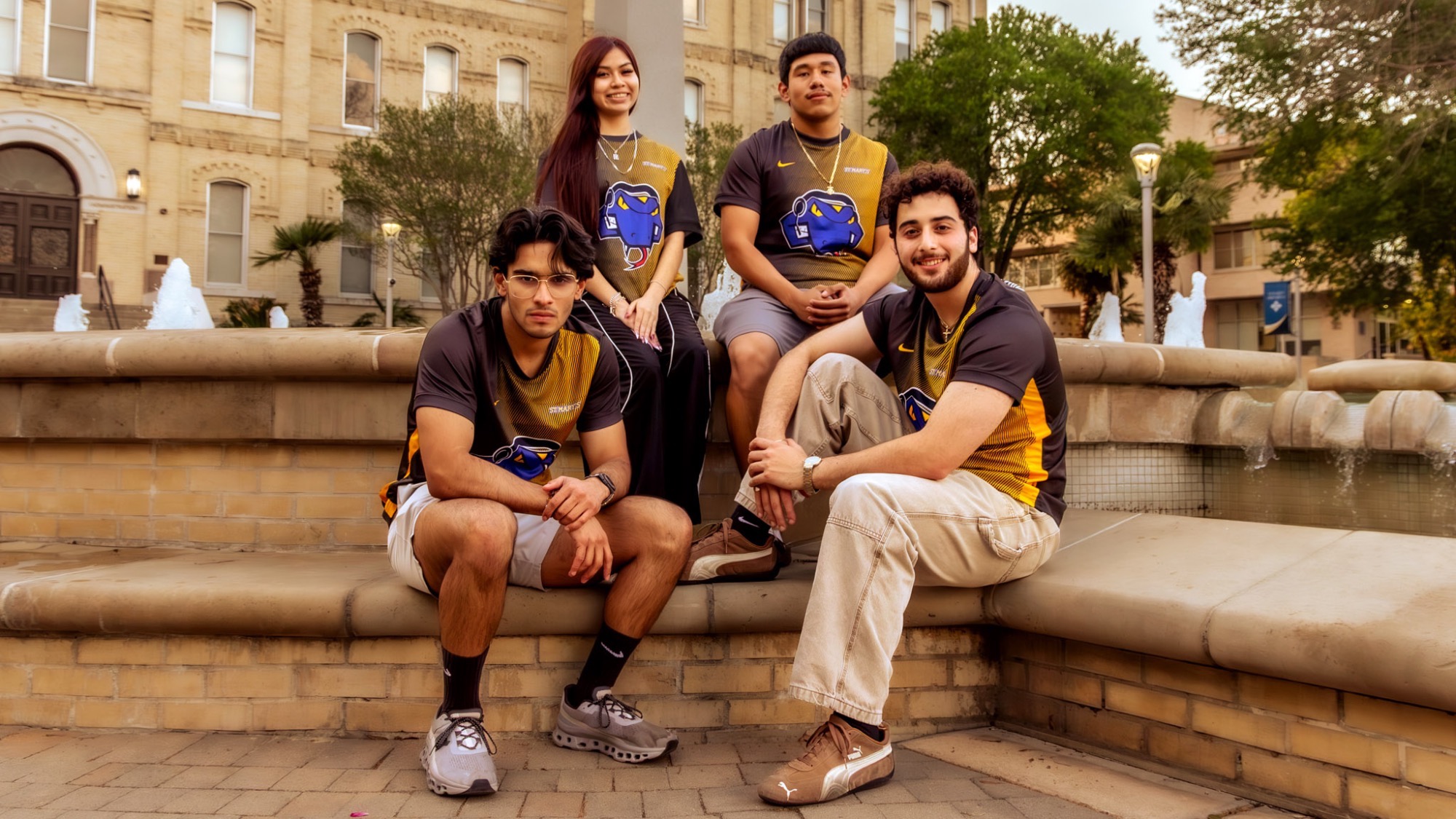 The four Call of Duty team members sit around the fountain on campus.