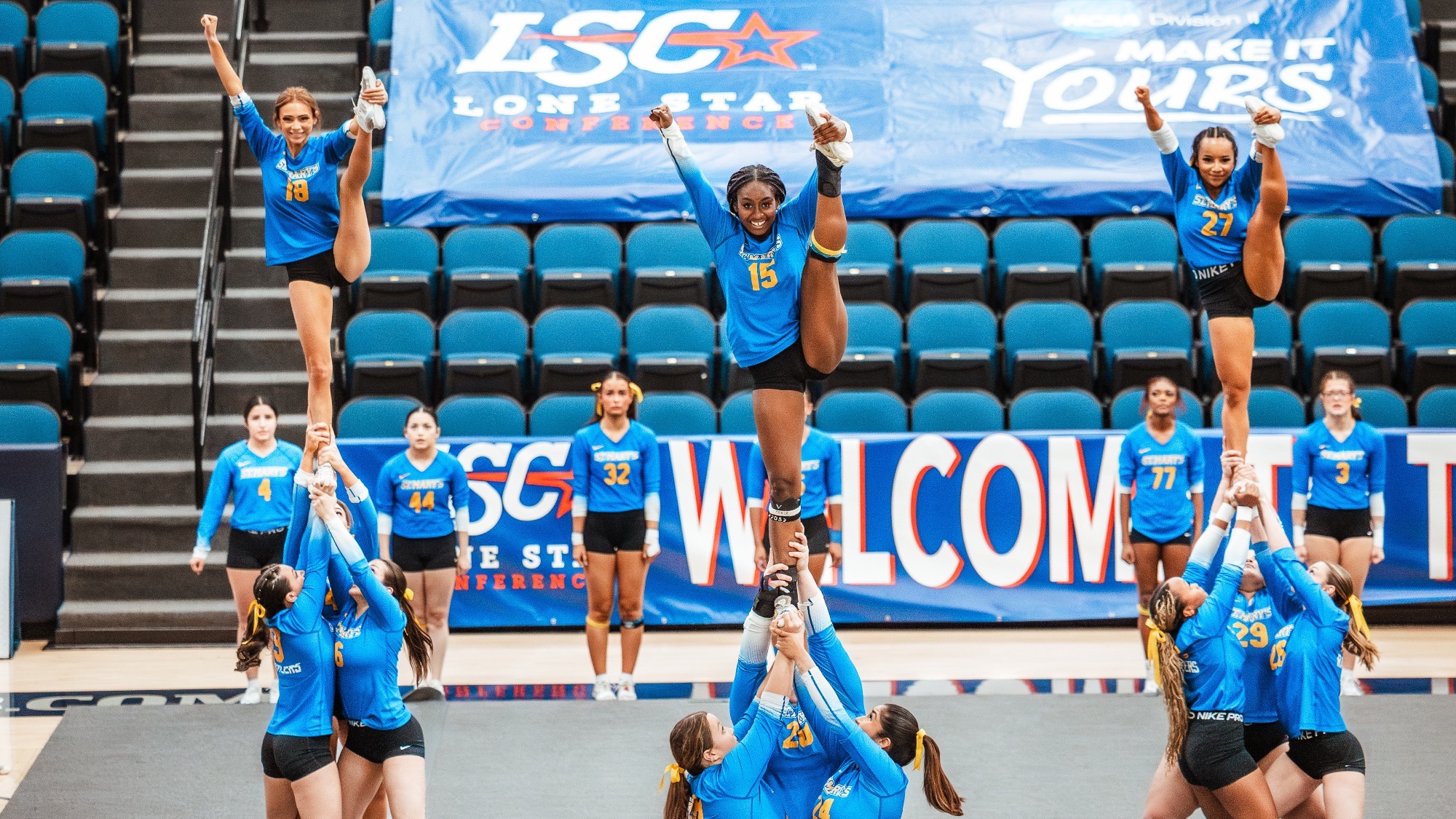 The three groups lift a trio of seniors into heel stretches at the LSC Championship. Yanelle Nicholson, Sydnye Forde and Alecka Brown are at the top.