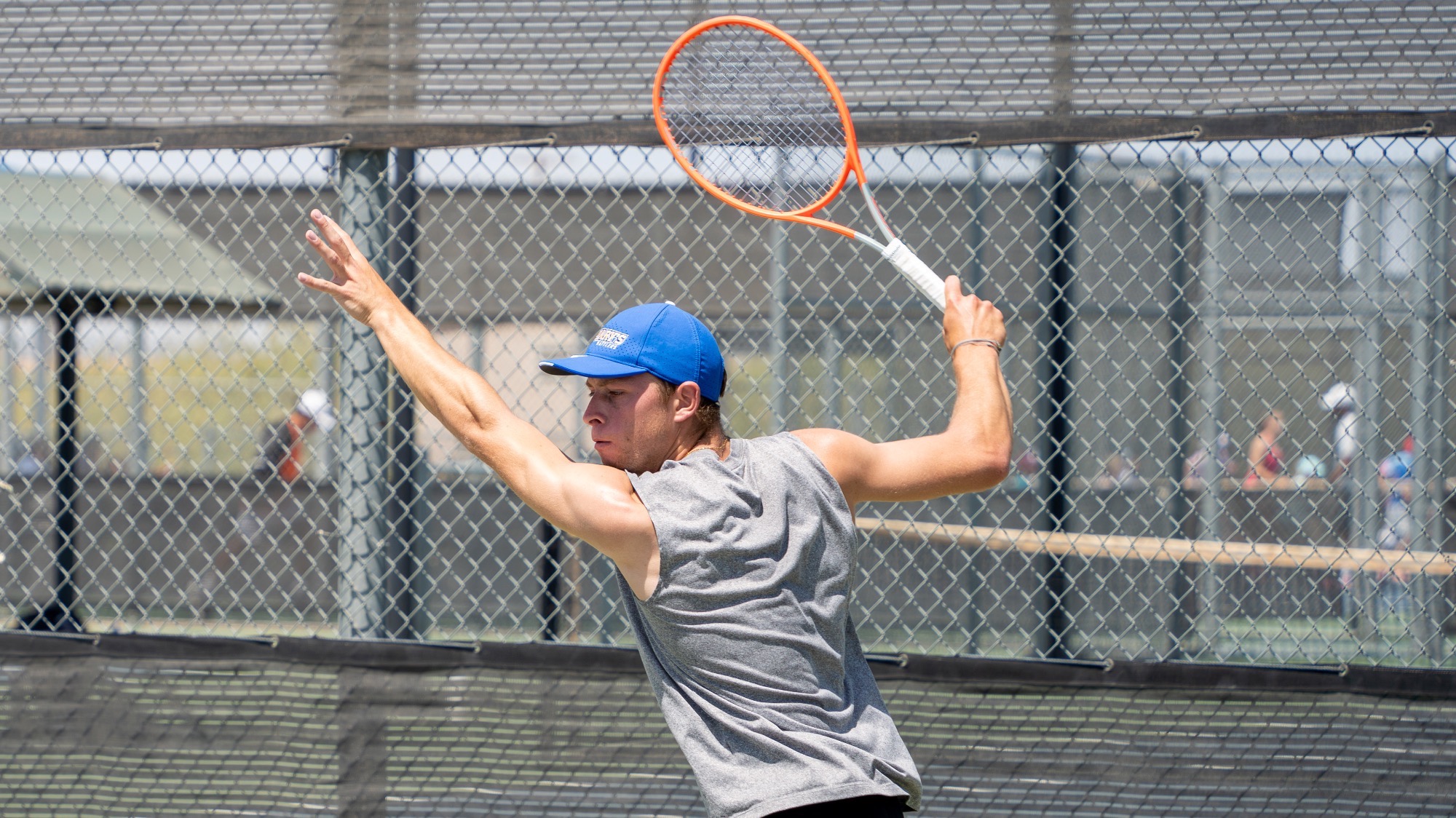 Florian Smalto swings back in preparation to hit a one-handed forehand.