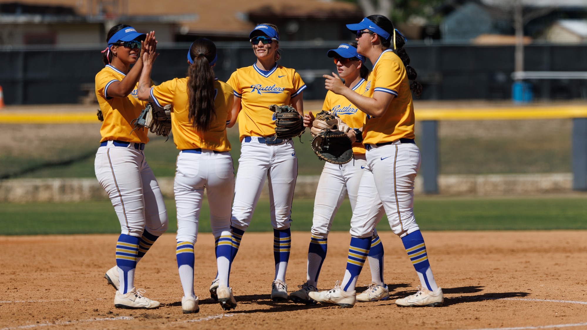 The infielders all surround pitcher Emery Aguilar to give high fives.