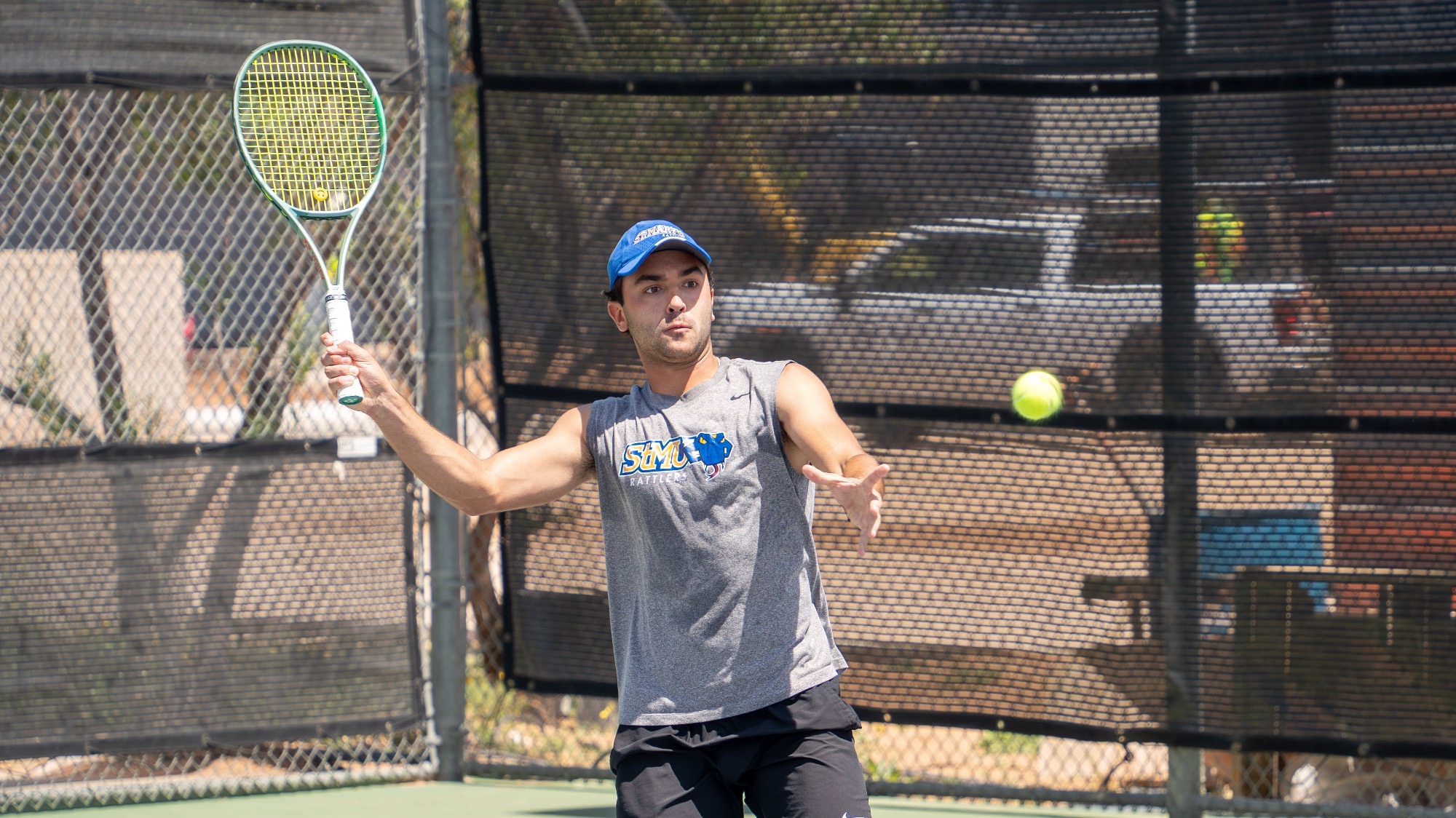 Aaron Ben Anton holds his racket perpendicular to the ground as he begins a forehand return.