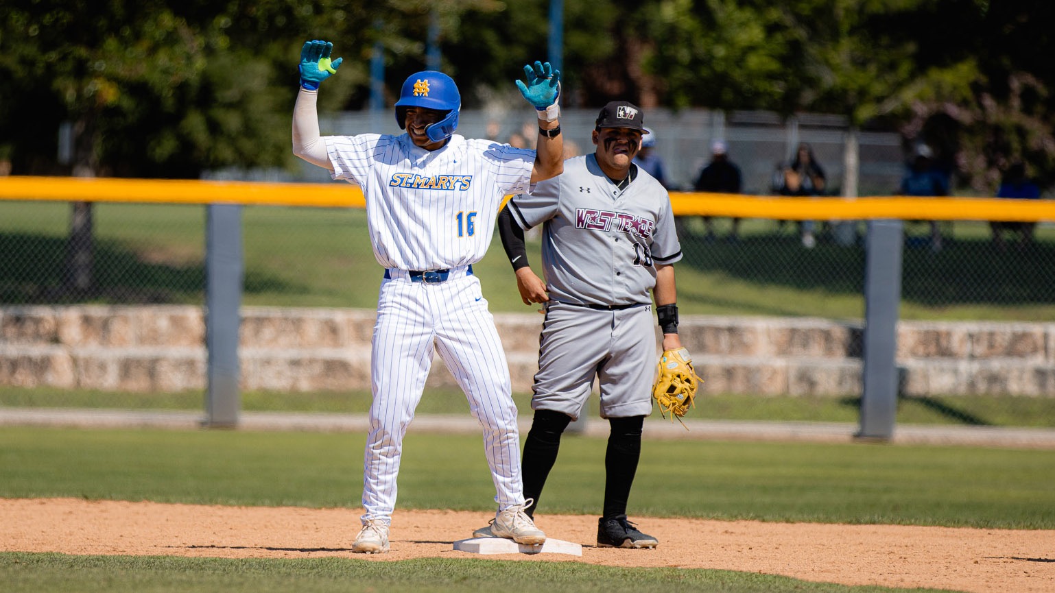 Matt Mendez stands on second base with his hands extended in celebration after doubling against WT.