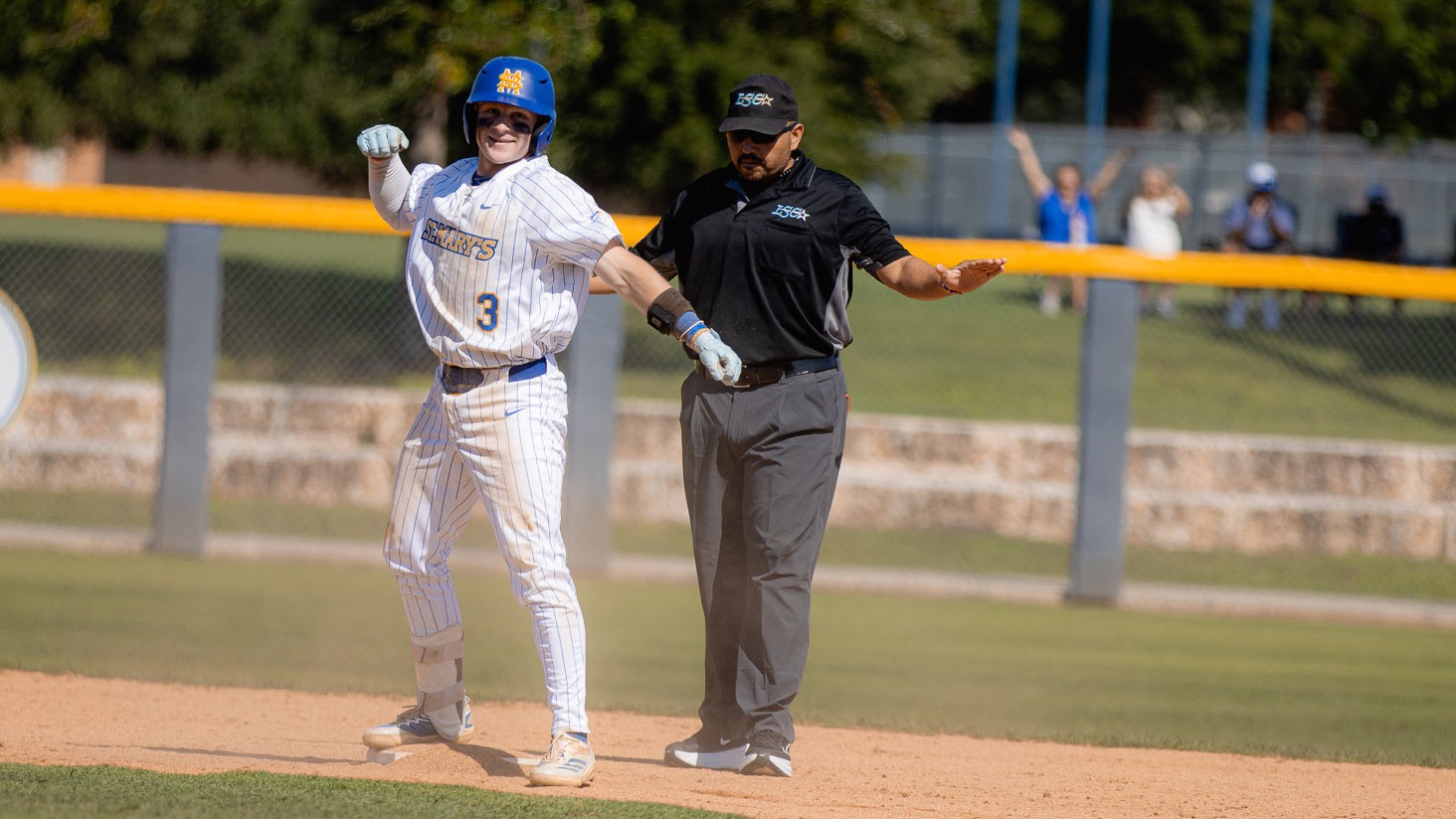 Ashton Beaird stands on second base with fist pumped after stealing the base. The umpire behind him signals safe.