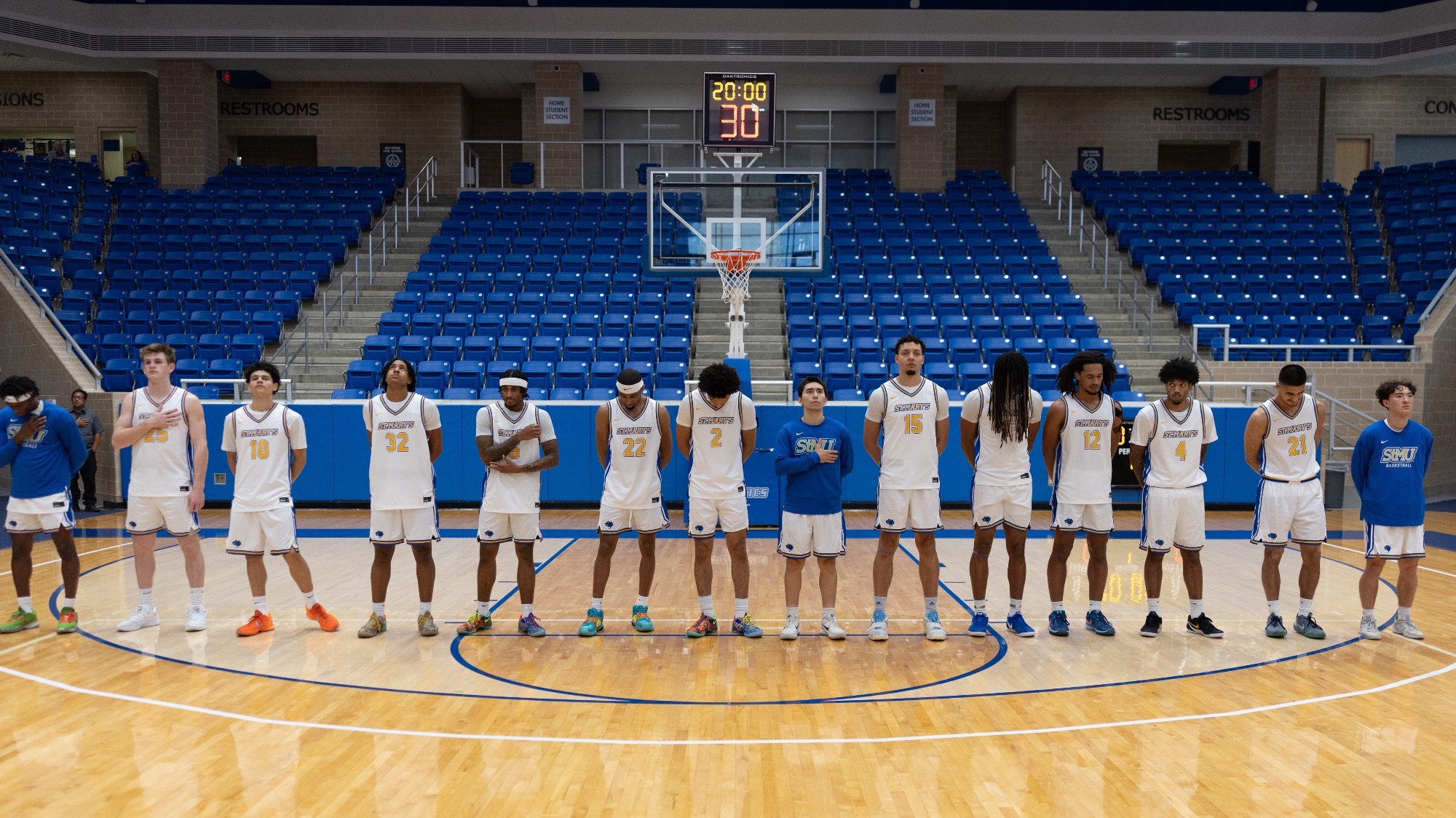 The 2025-26 Men's Basketball team stands in a line before the national anthem plays.