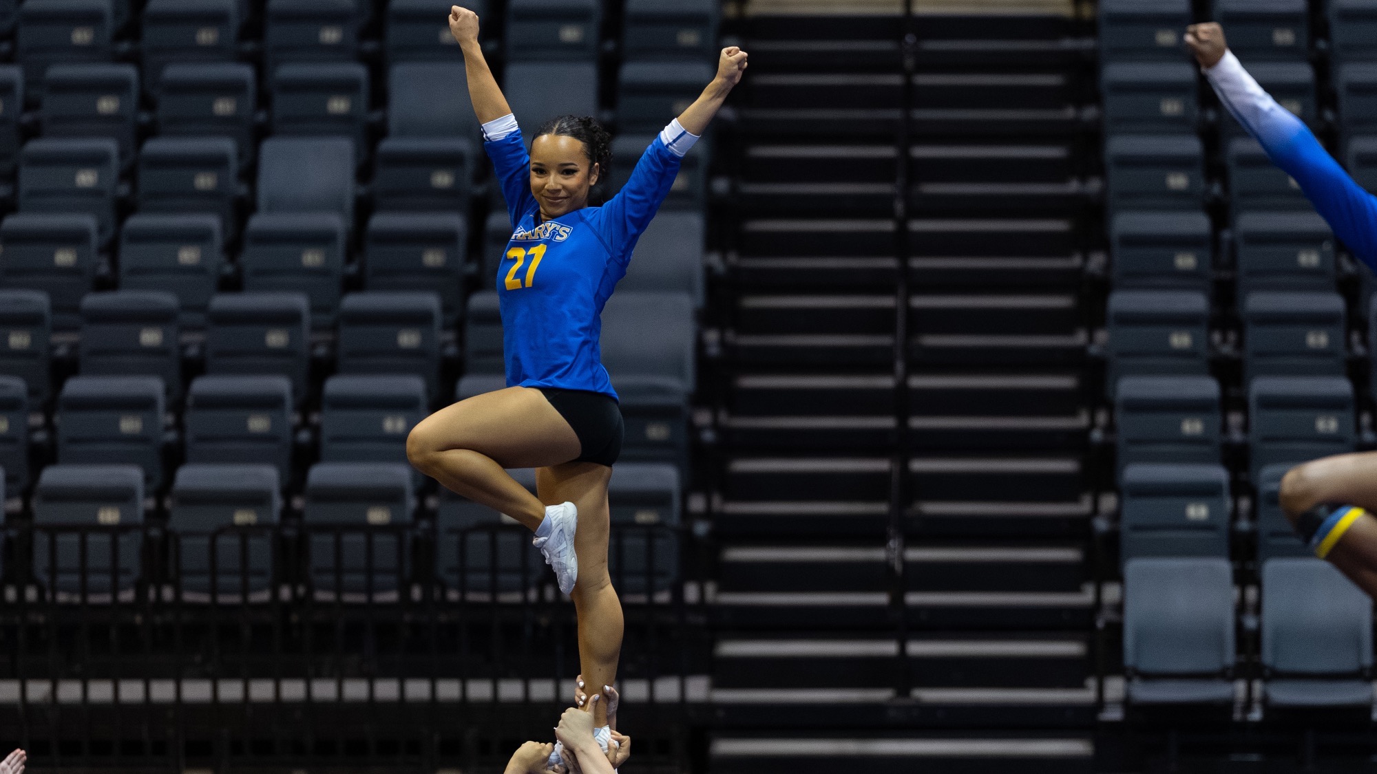 Alecka Brown is being held in a liberty pose by her teammates.