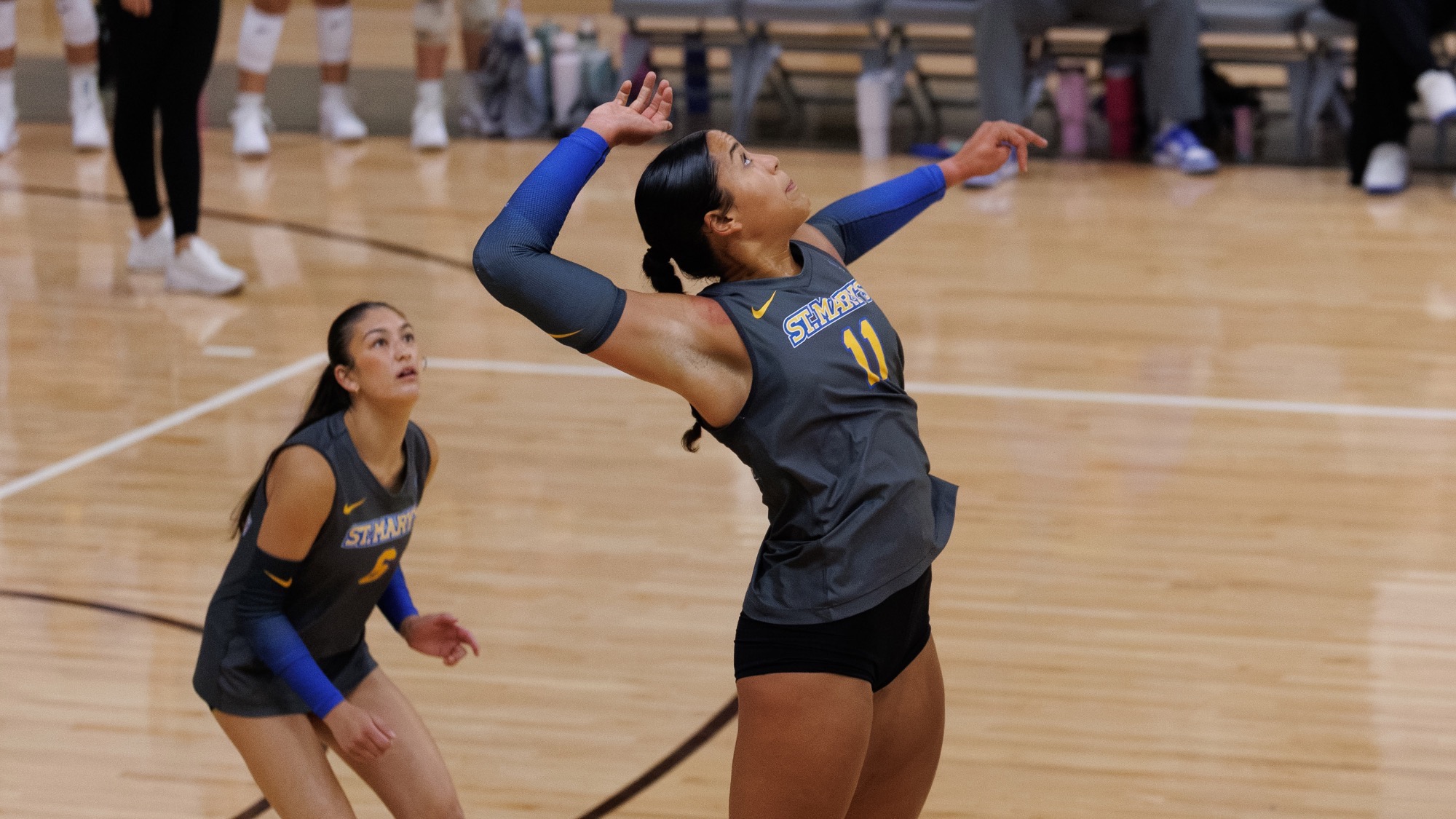 Laurene Robinson goes up for a swing on the right side at Trinity with Emerson Chang in the background ready to cover.