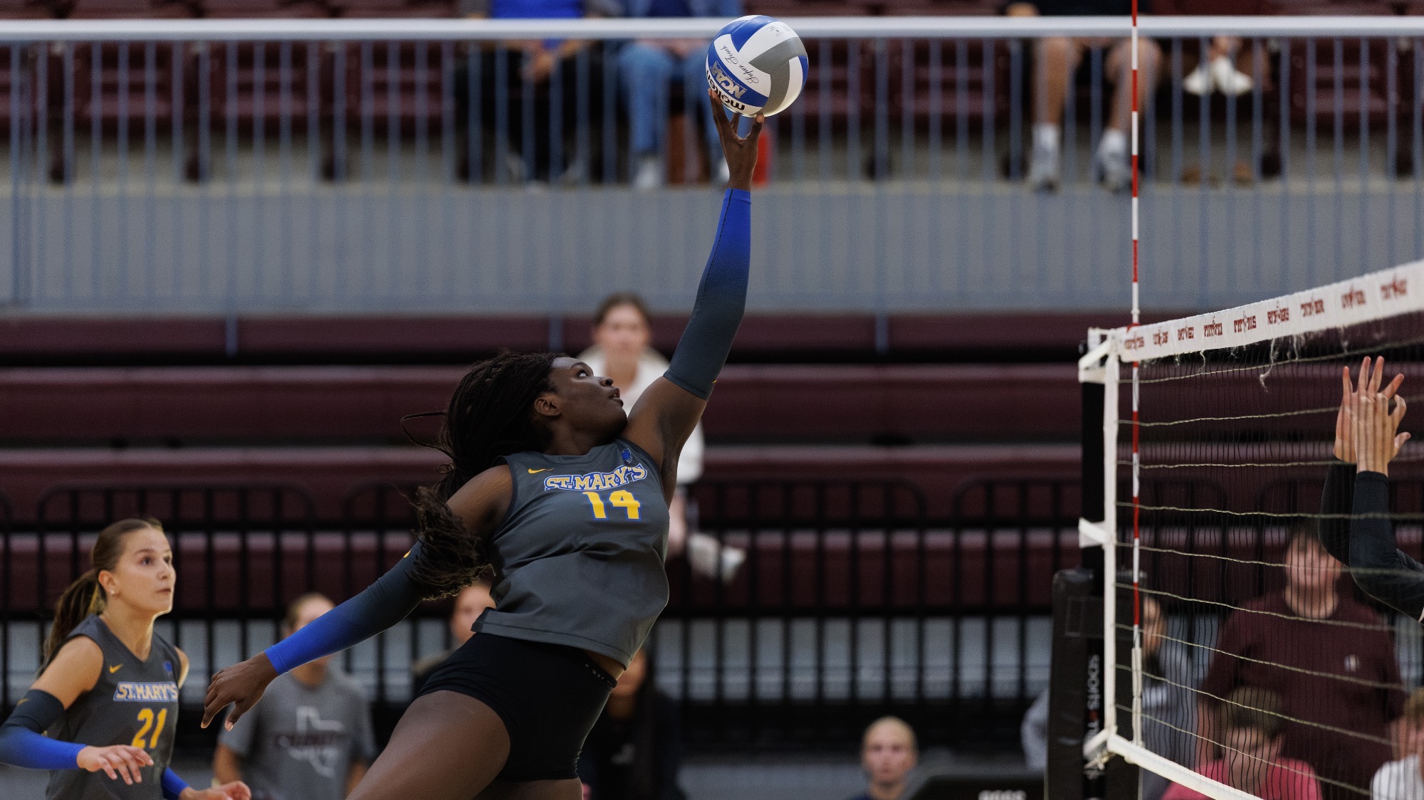 Madyson Carr reaches up to tip a ball at Trinity.