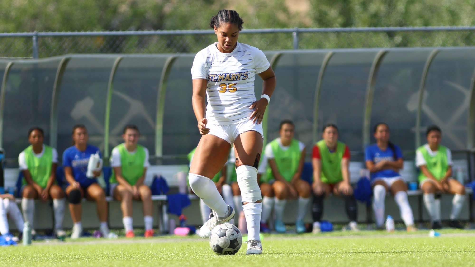 Kamora Hall looks down at the ball as she prepares to kick it.