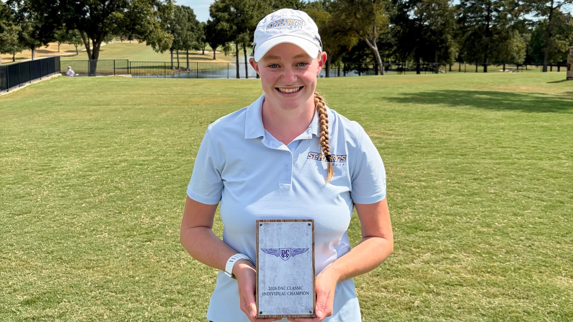 Taylor Wilczek stands on the course holding the 2026 DBU Classic trophy.
