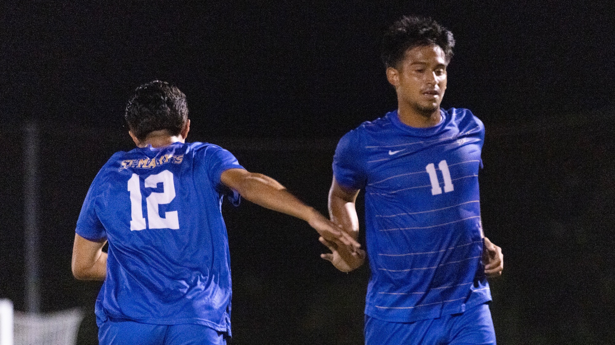 Eduardo Fernandez and Sebastian Poblete give each other a high five as they pass each other on the pitch.