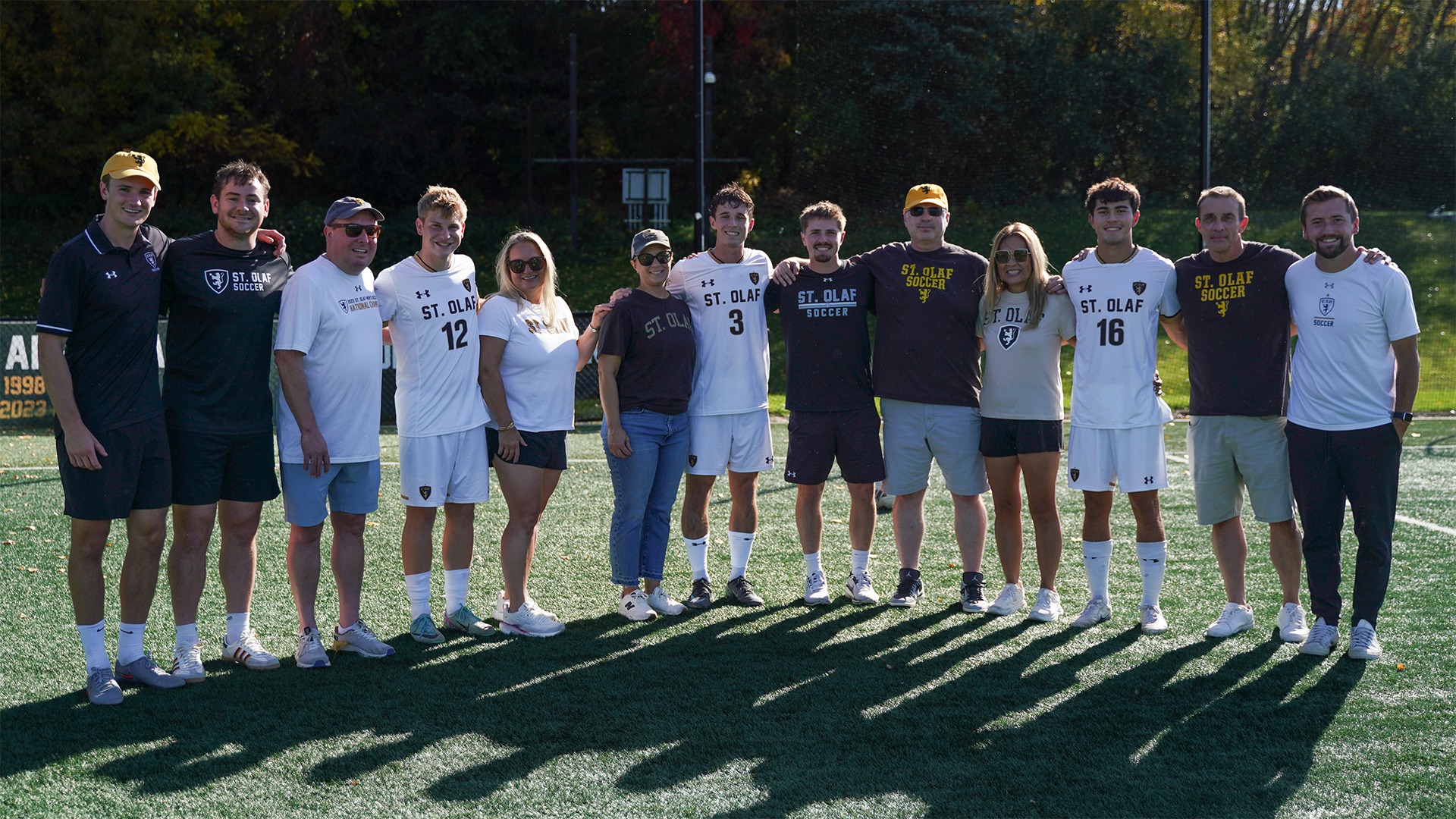 The St. Olaf men's soccer team's seniors and families pose for a photo.