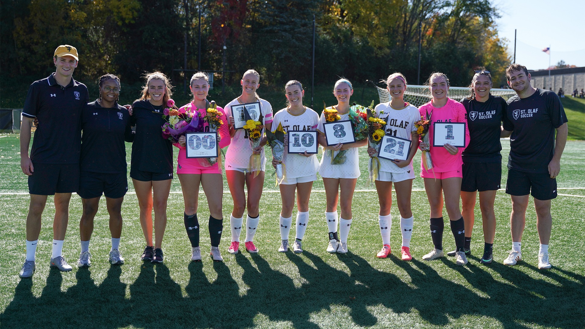 Women's soccer's senior class and coaches pose for a photo.