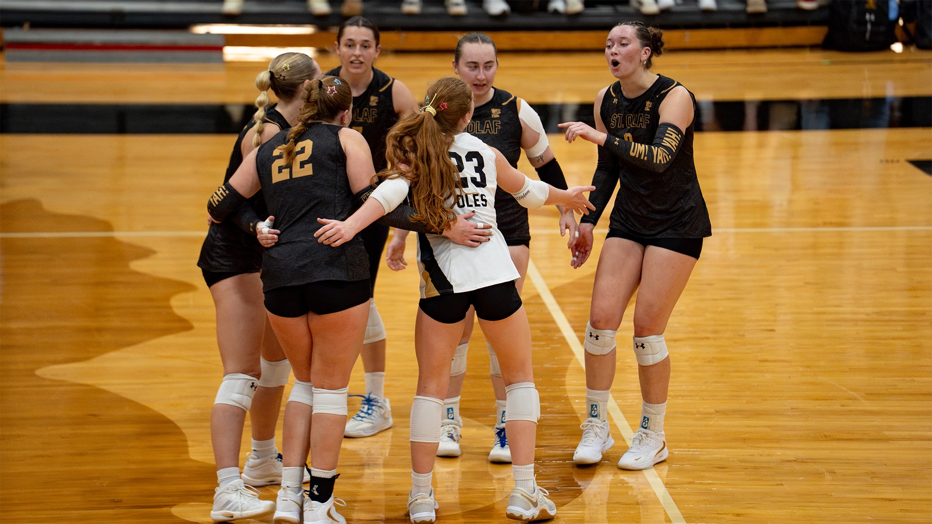 The St. Olaf volleyball team celebrates after a point.