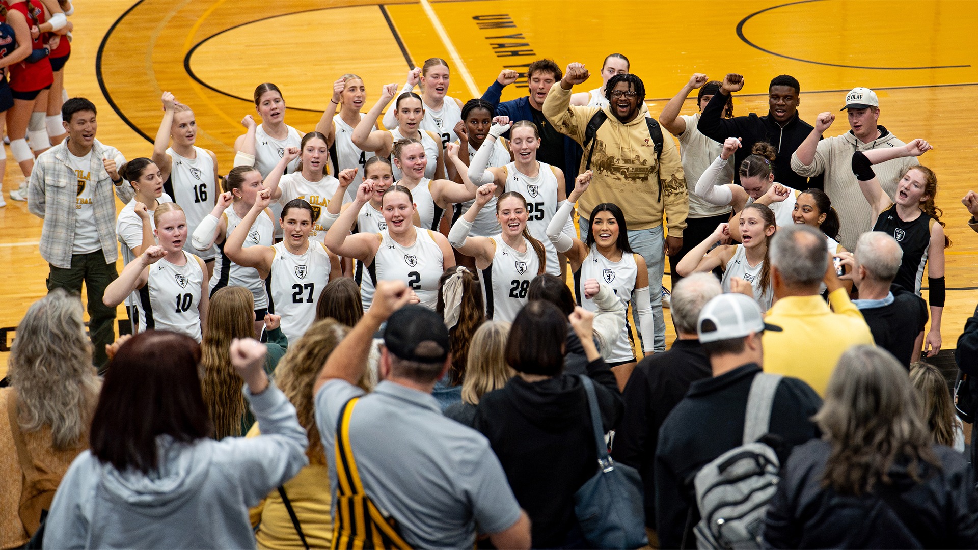 The St. Olaf volleyball team sings Um! Yah! Yah! after beating Saint Mary's.
