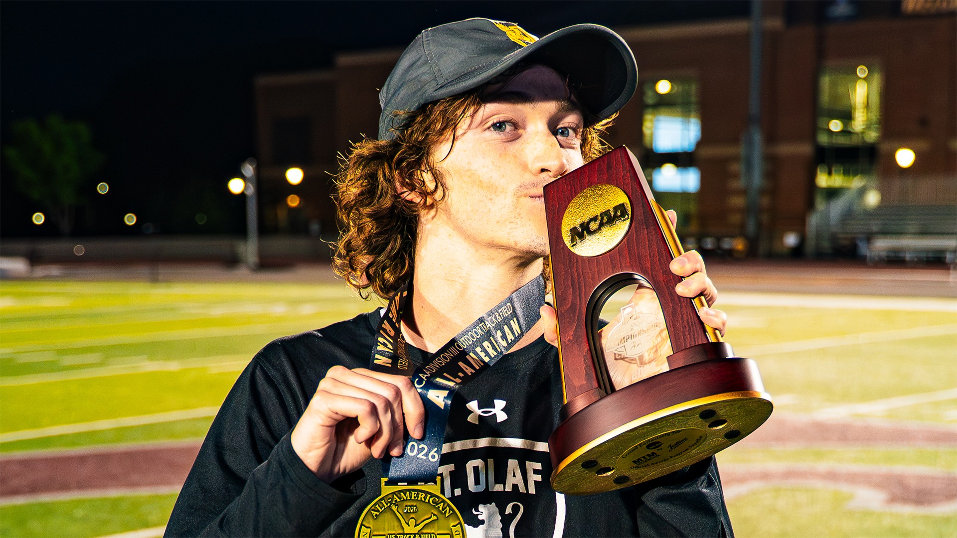 Kevin Turlington holds up his All-America medal and trophy.