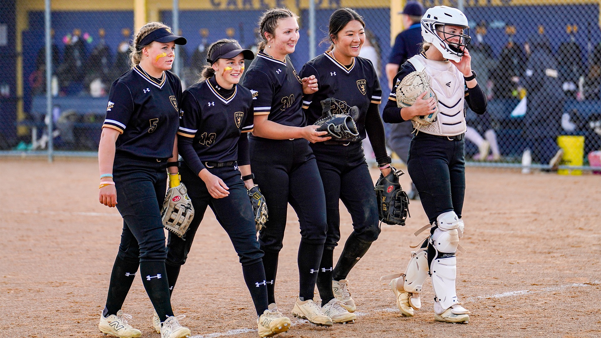 Members of the St. Olaf College softball team walking off the field between innings.