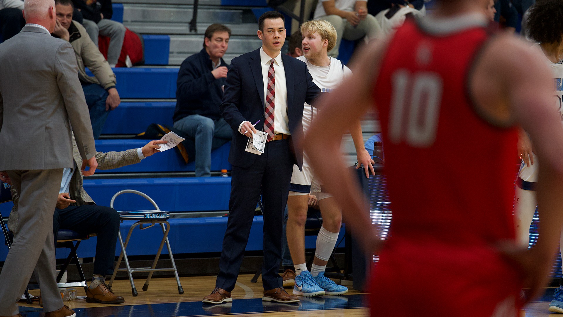 John Cheng stands on the sideline at a game.