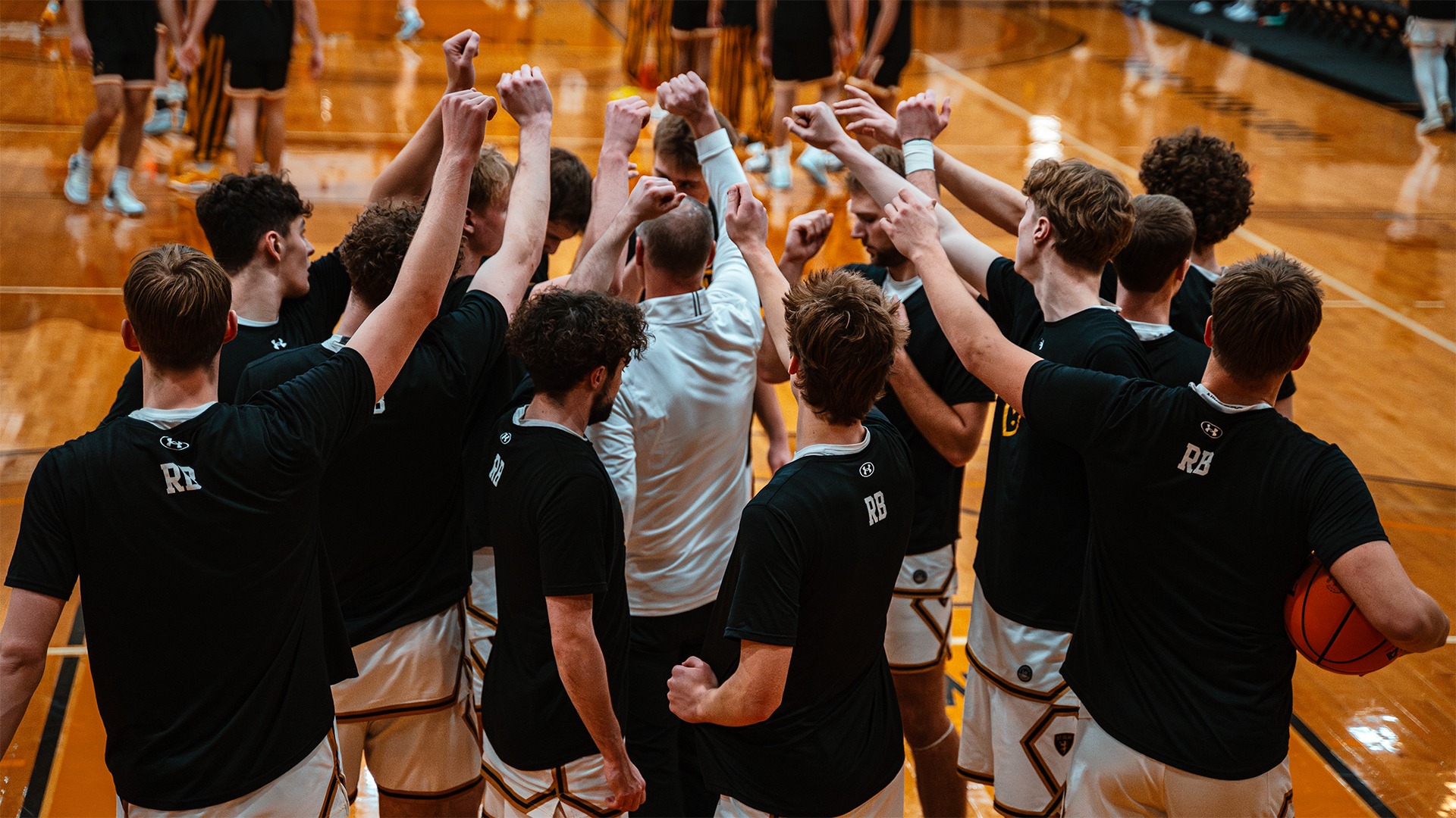 The St. Olaf men's basketball team huddles before a game.