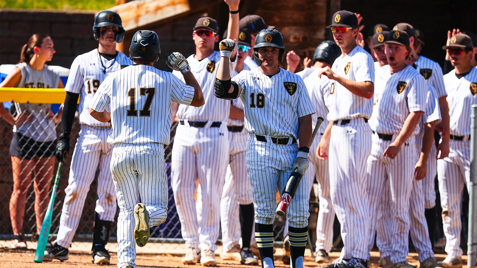 Henry Black greets Mason Buck at home plate after Buck scores a run.