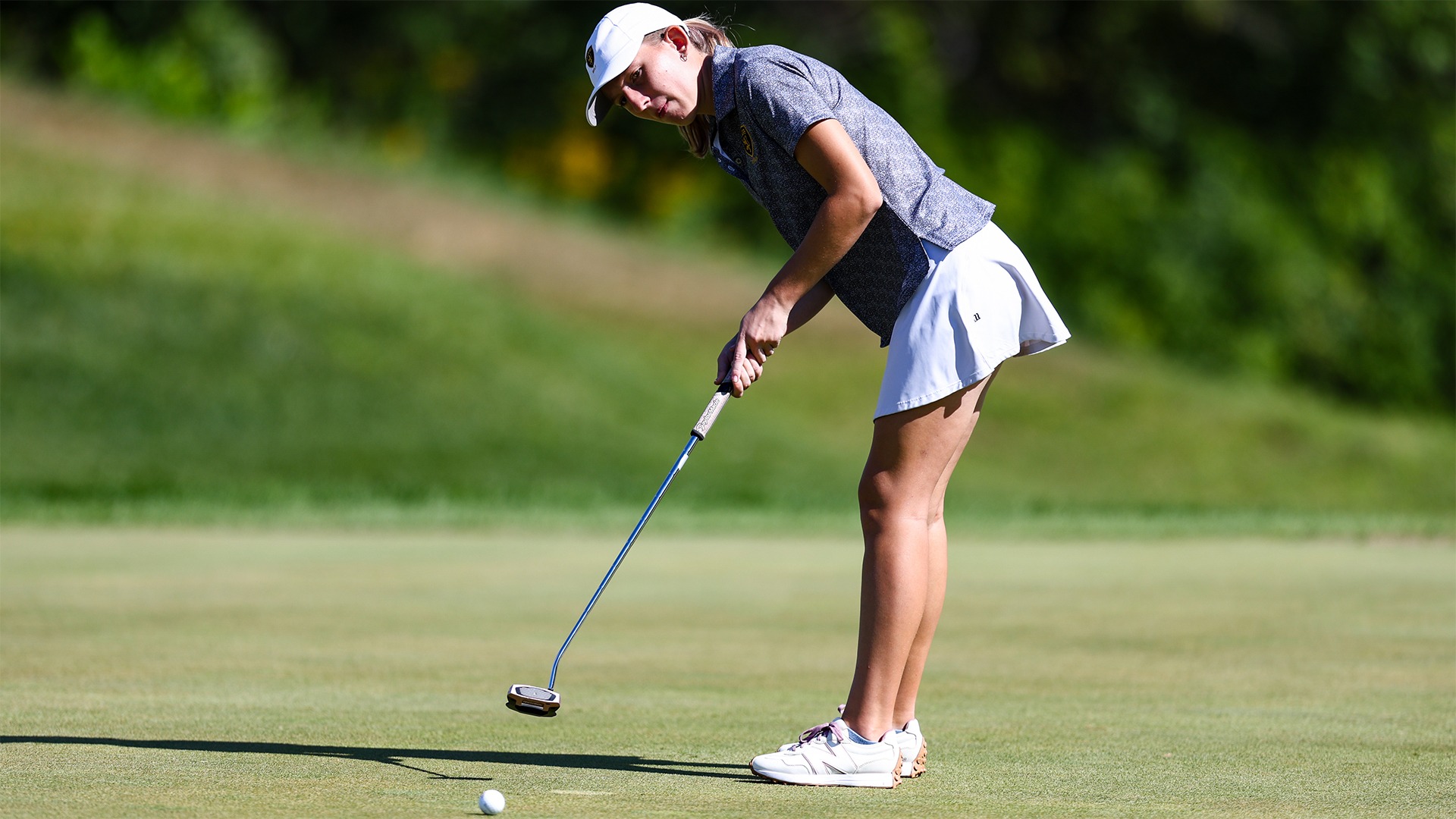 Amita Crowley hits a putt.