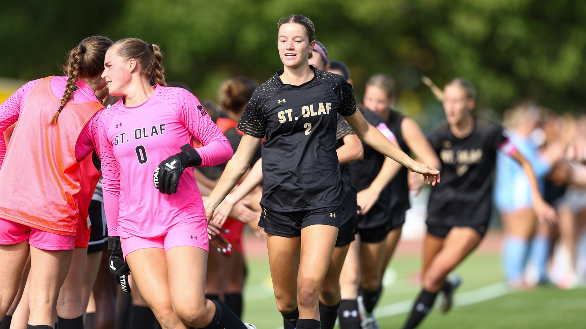 Rachel Anderson high-fives her teammates before a game.
