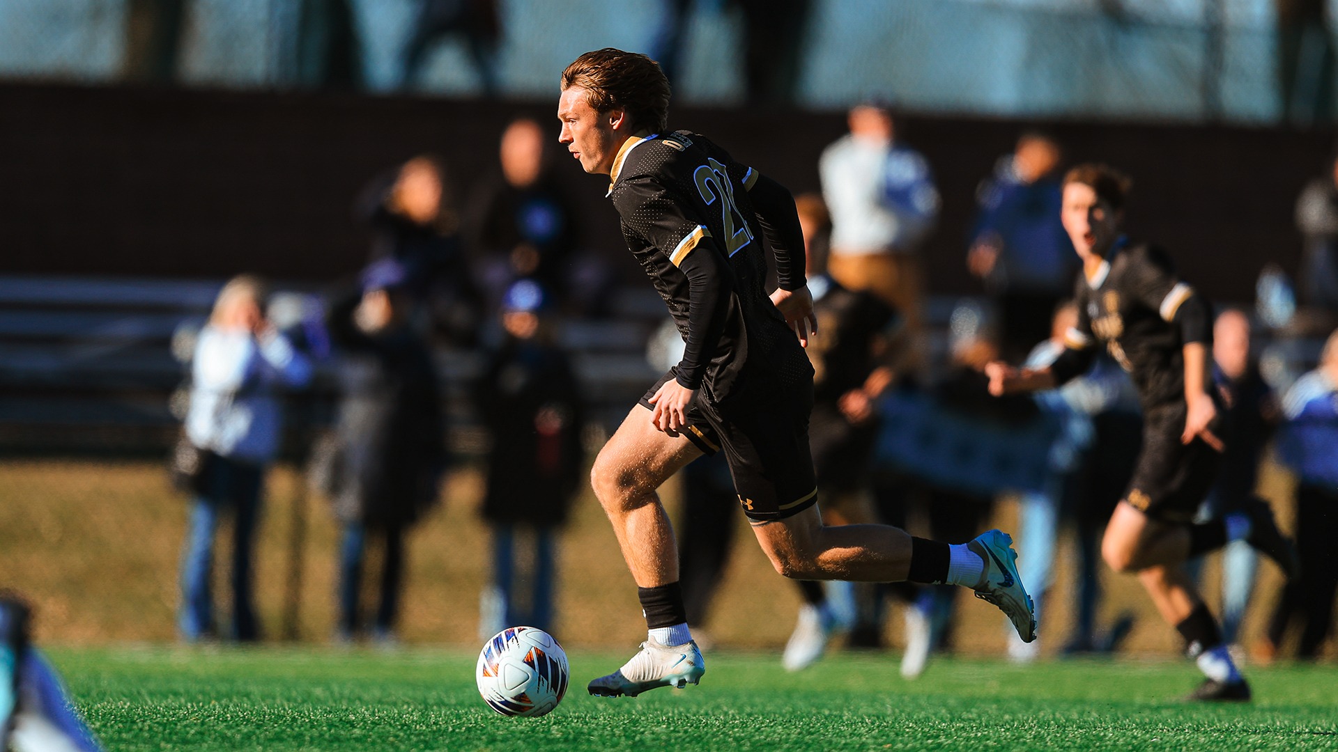 Charlie Piller dribbes up the field against Wheaton.