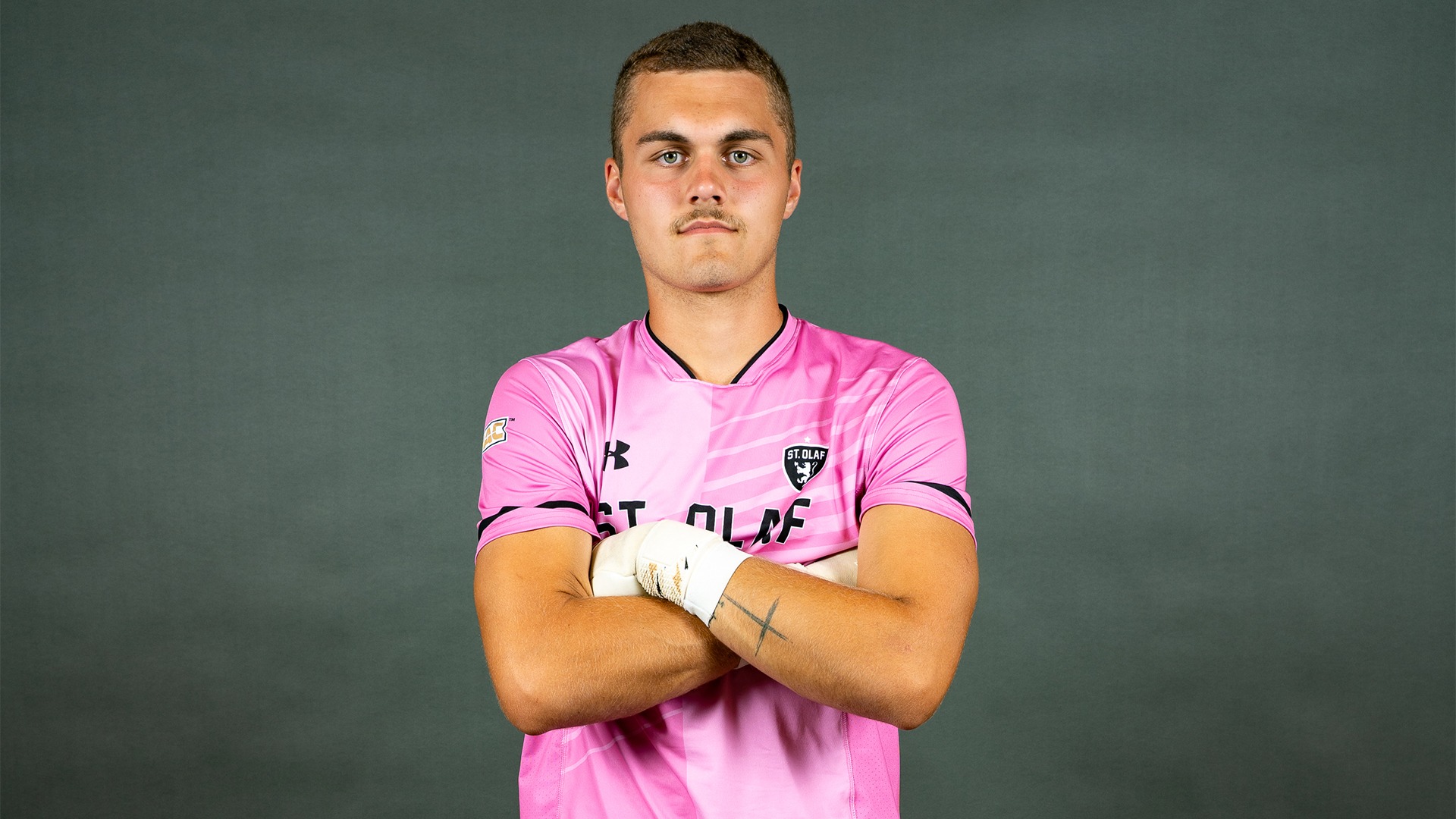 Beckett Carlson stands with his arms folded on photo day.