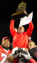 Head football coach Chuck Priore celebrates with the Big South trophy