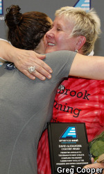 Moira Alexander (right) shares embrace with UNH's Lauren McCandless before presenting her with the Dave Alexander Coaches Award at the 2014 America East Championship.