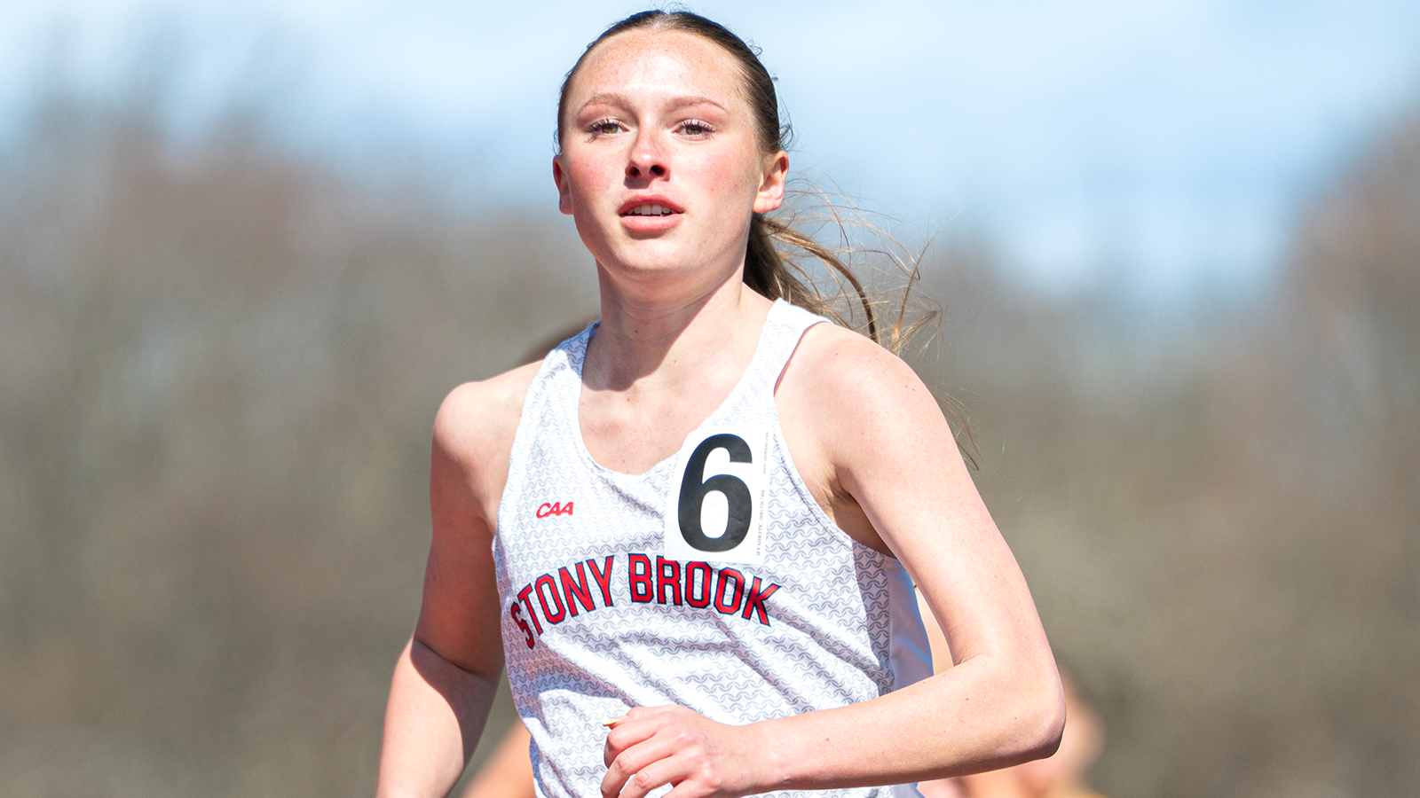 Danielle Birner running down the track with several runners behind her in background. 