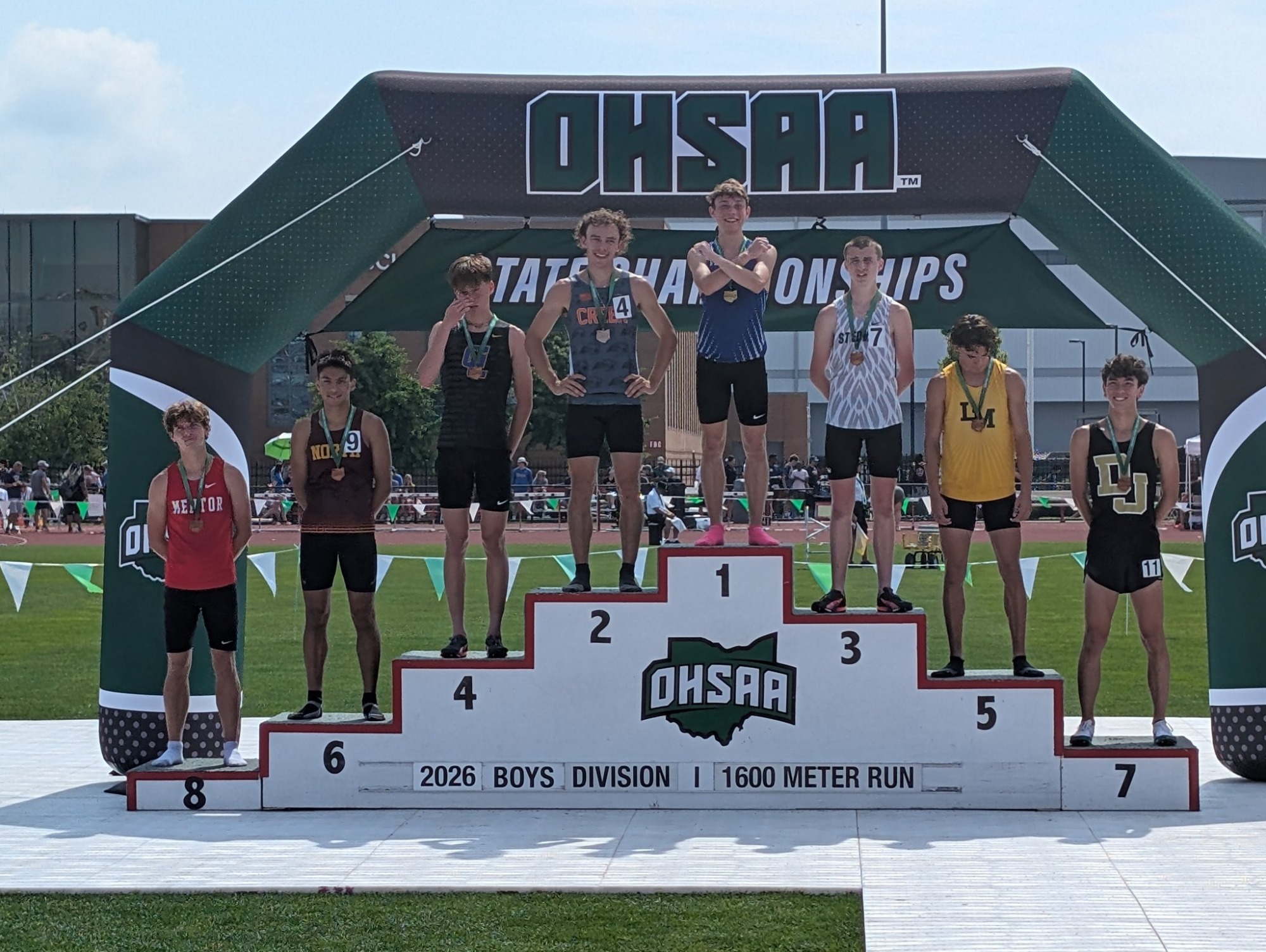 Senior Dom Ellis flashes the X as he stands a top of state final podium