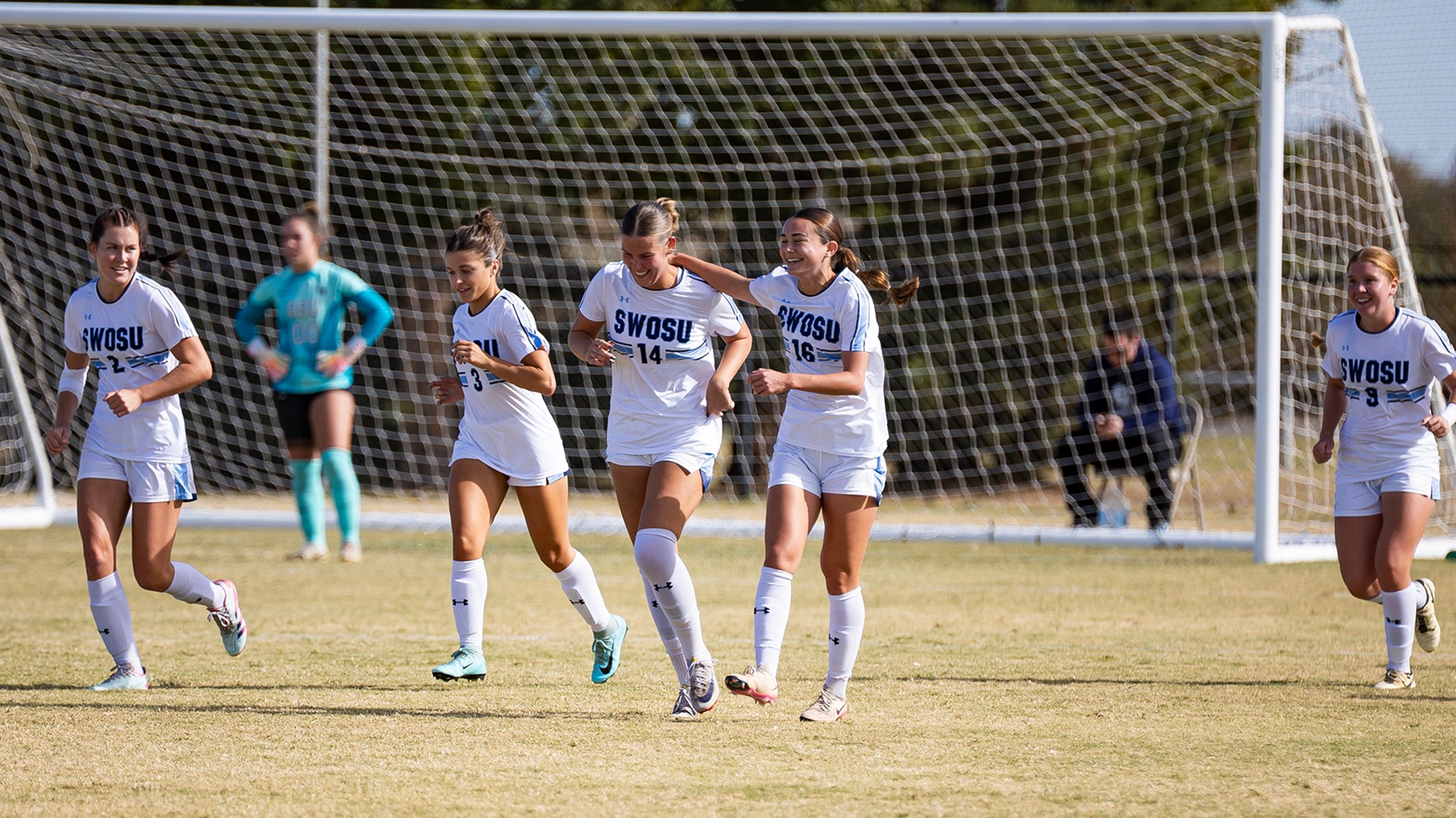 Soccer team members Celebrate after a goal against Oklahoma Baptist