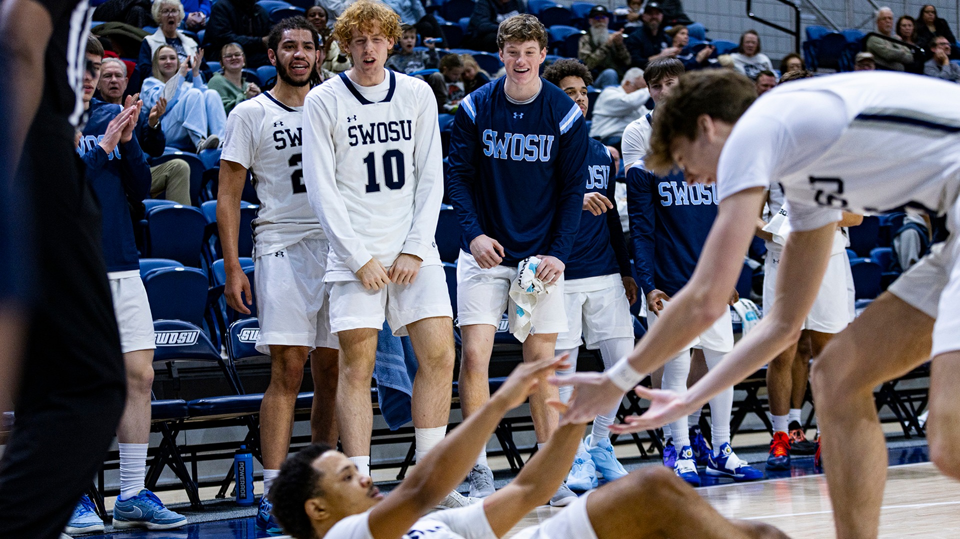 men's hoops bench celebrates a charge call