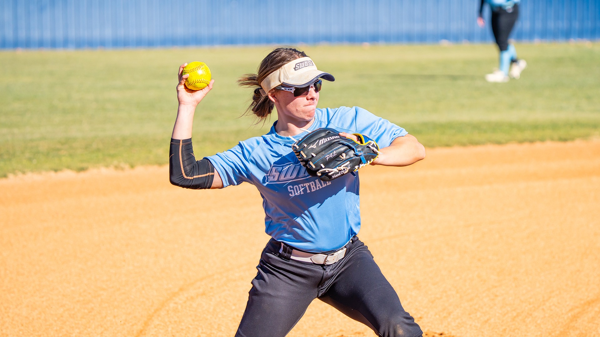 swosu softball player throwing a ball in the infield