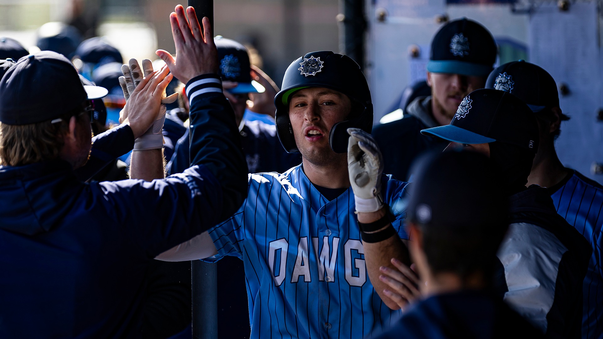 nolan mccrossin high fives his teammates in the dugout after scoring