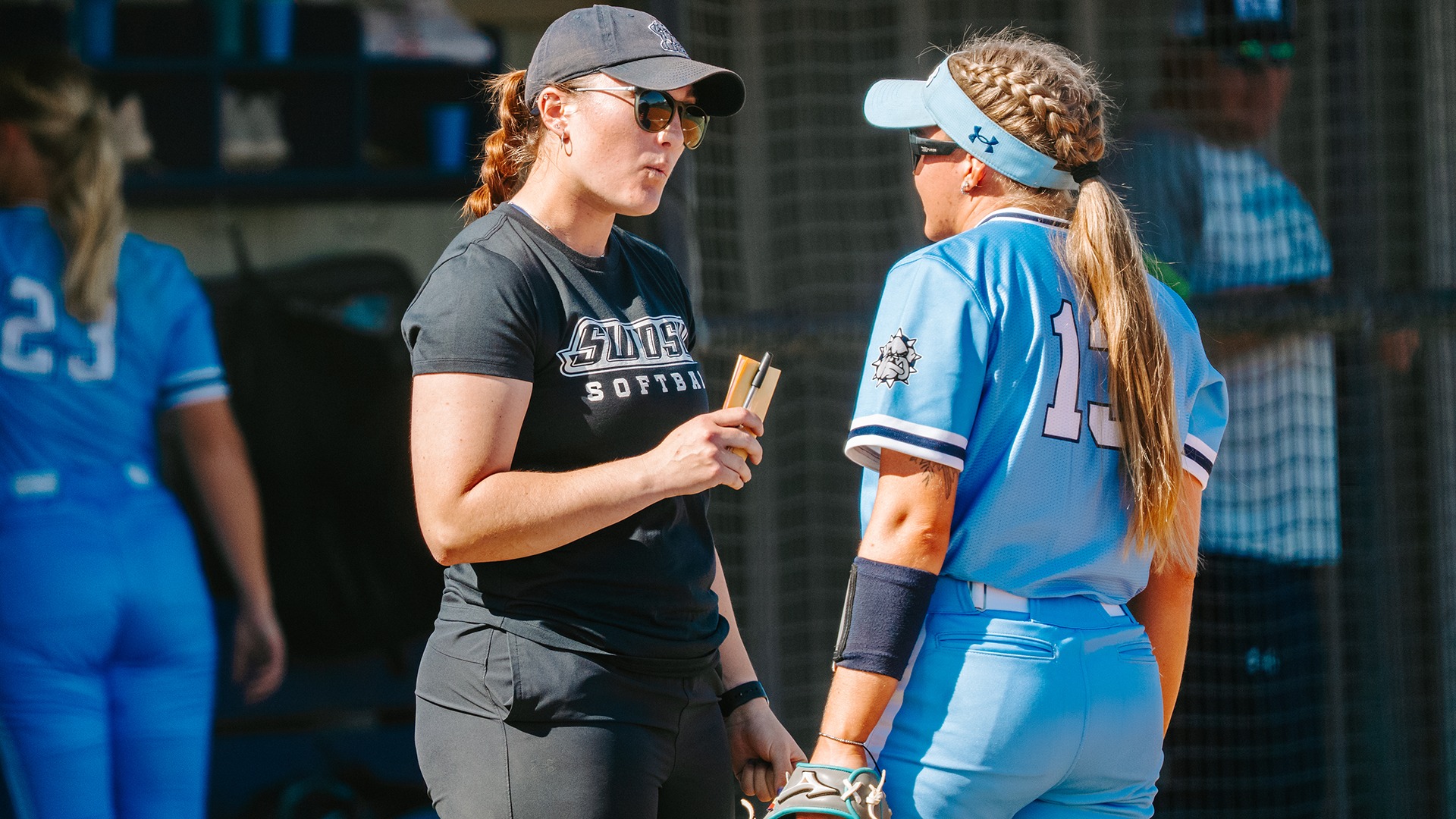coach cheyenne mahy talks with skyla mcphillips in between innings