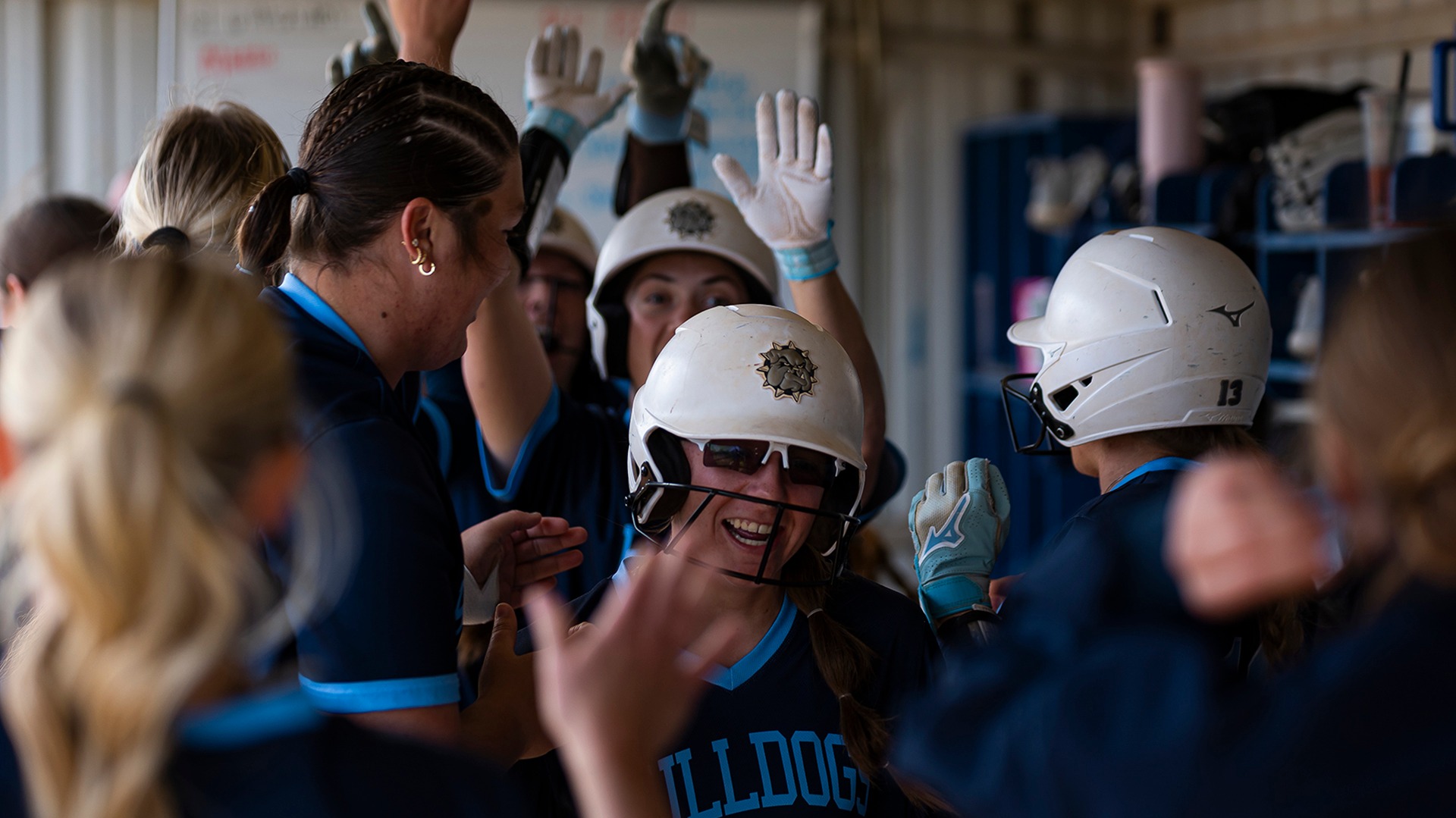 kennedi caine celebrates in the dugout after scoring a run
