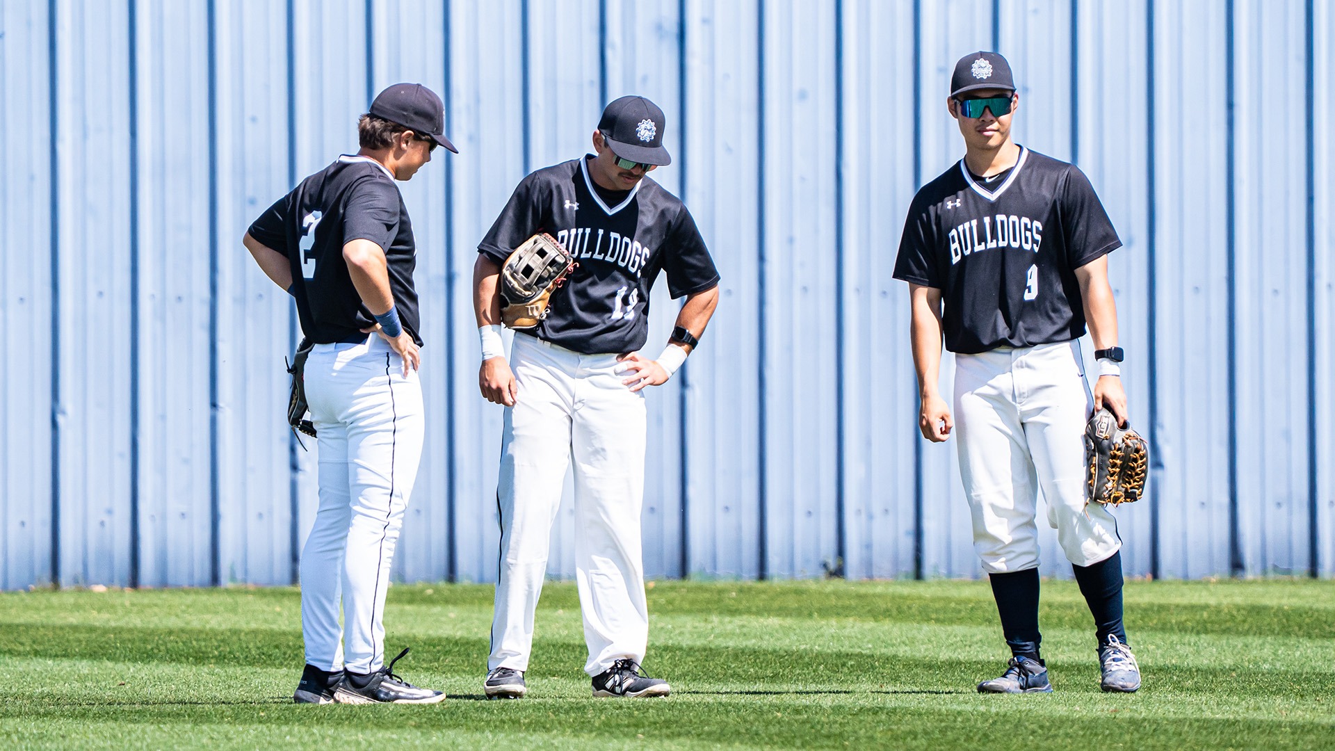 SWOSU outfielders stand next to each other during a stop in action