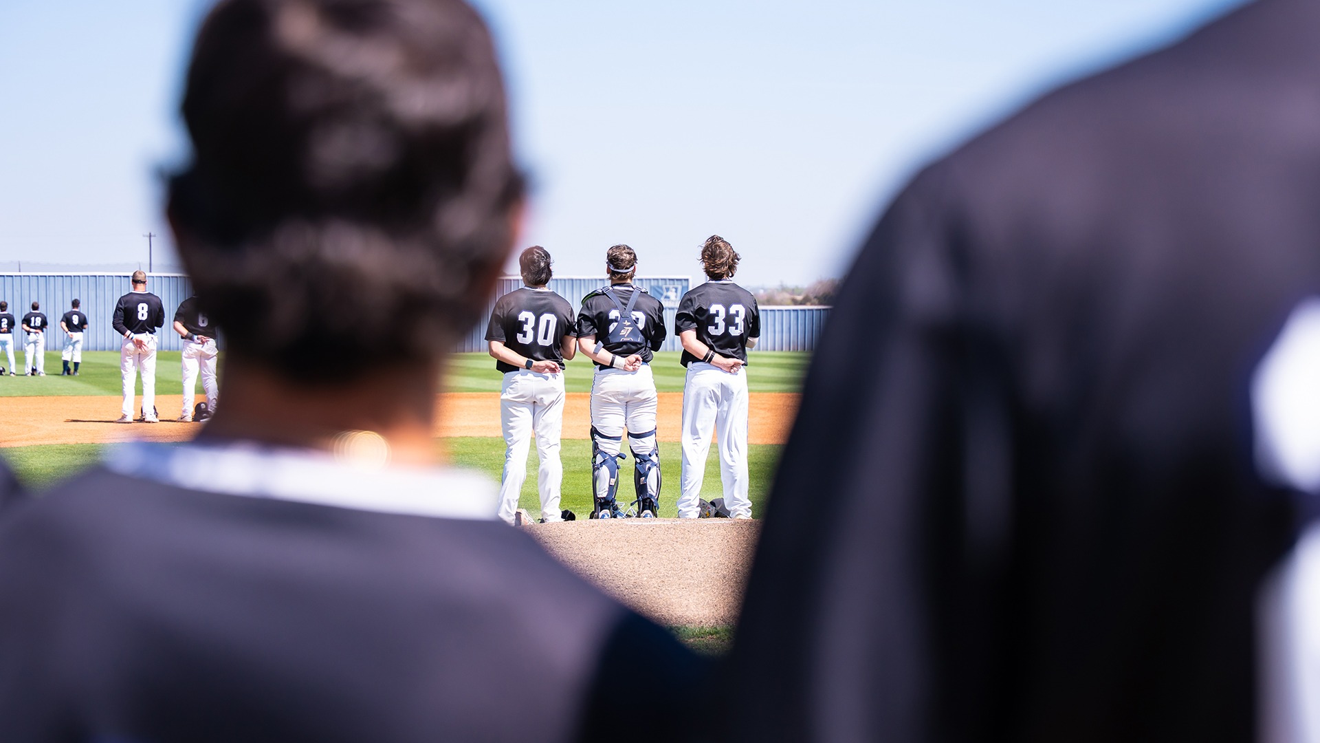 swosu baseball players stand during the national anthem before a game