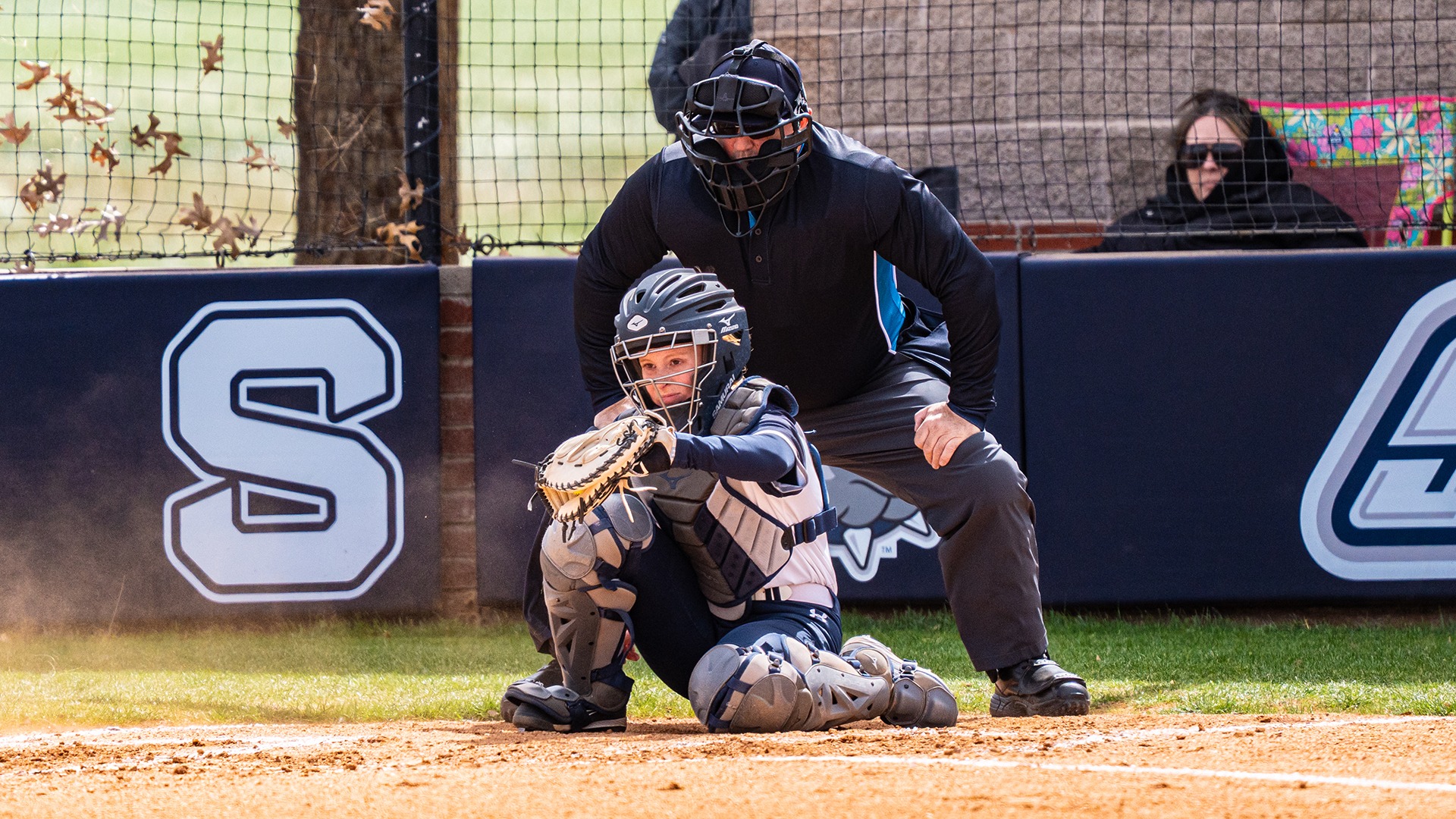 taylor mcmahon catches a ball behind home plate in her gear