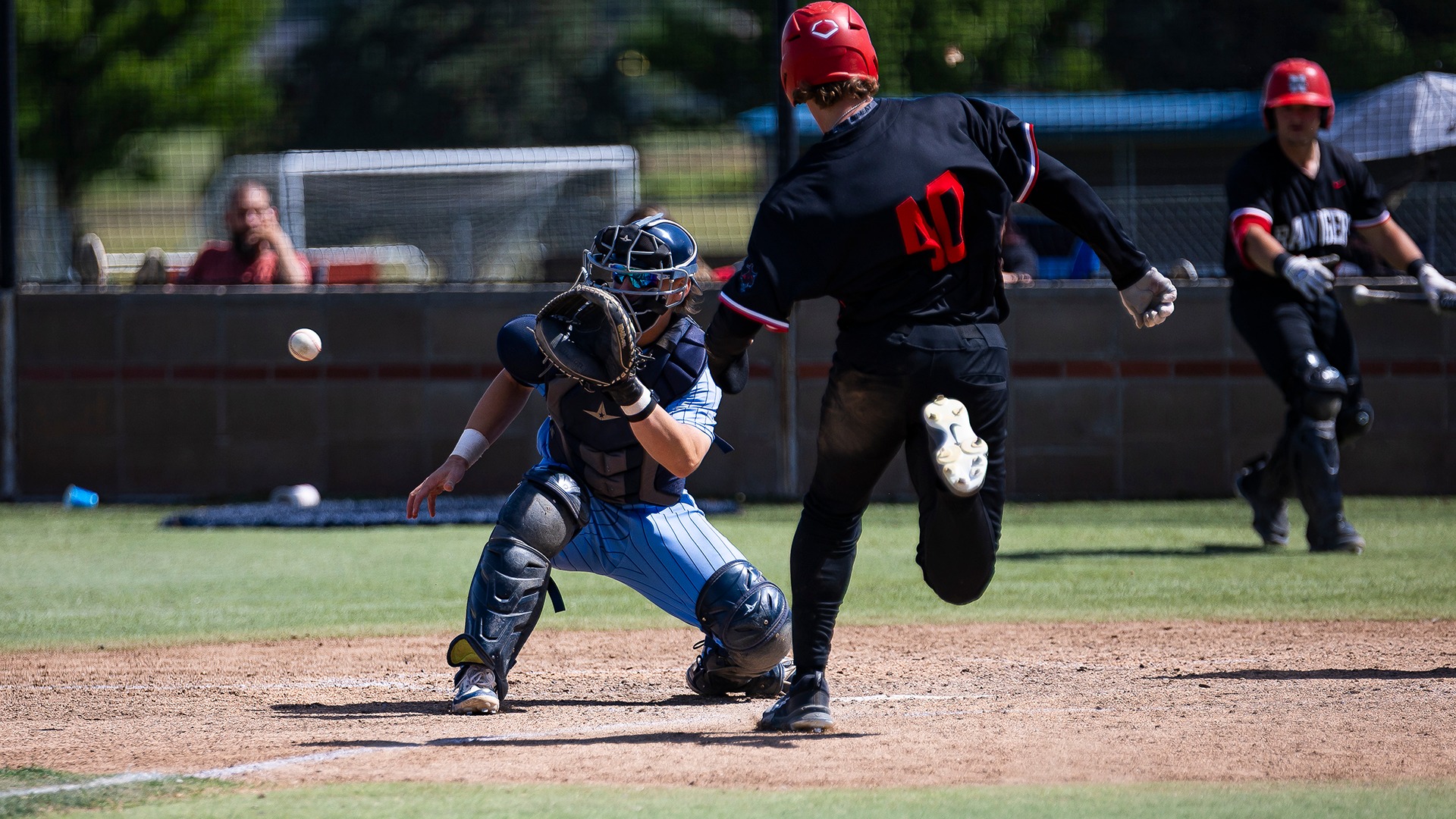 rusty wortman gets ready to catch a ball at home plate at a play at the plate